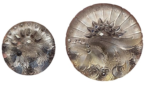 A pair of division one lacy glass buttons