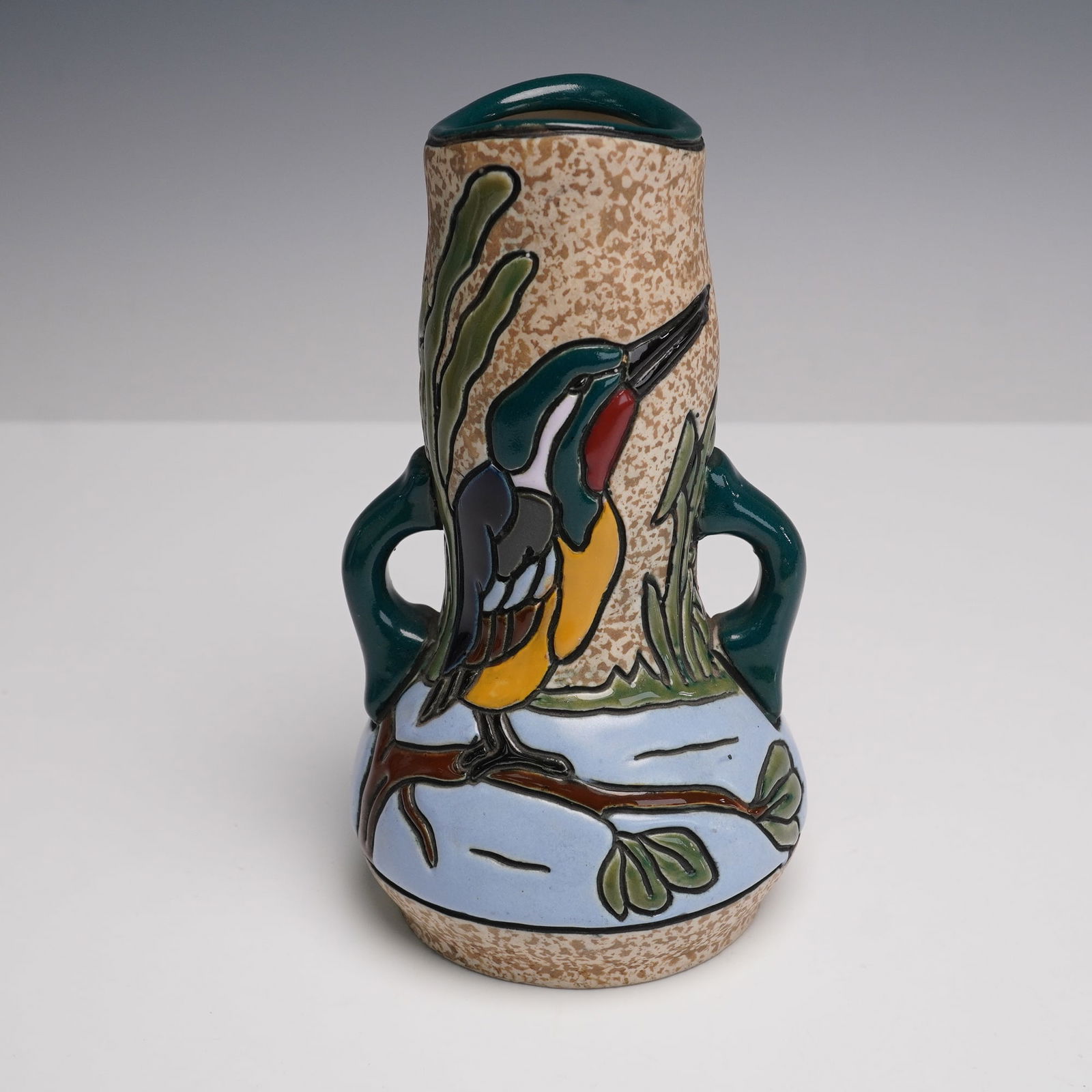 Amphora Czechoslovakia Campina Pottery Kingfisher Two-Handled Vase: An Amphora Czechoslovakia pottery vase from the Campina series, decorated in high relief with a brightly colored kingfisher among reeds. The bird and foliage are highlighted in green, blue, and ochre