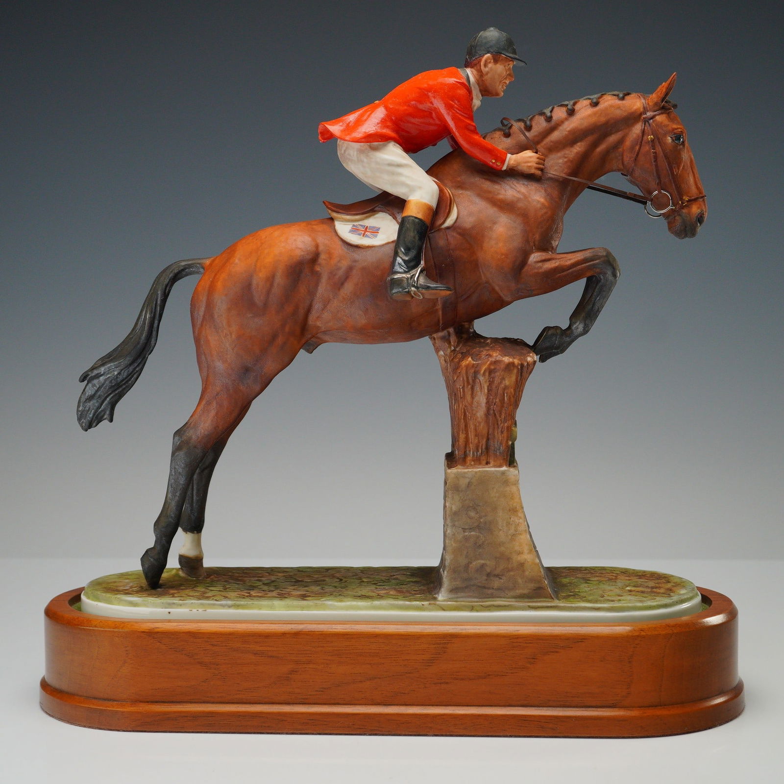 2pc Royal Worcester Figurine & Base, Fox Hunter: A distinguished Bone China equestrian sculpture stride his Olympic show jumper, Foxhunter. Rendered with exceptional intricacy, this dynamic composition captures the horse and rider mid-jump over a st