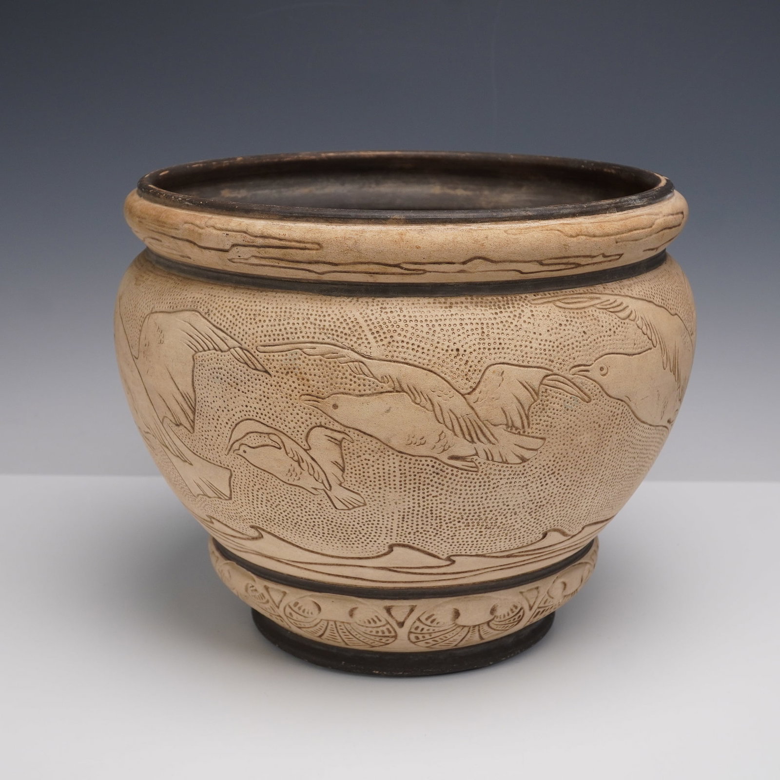 Weller Pottery Decorated Jardiniere: A fine early 20th century Weller Pottery jardiniere with incised and stippled decoration, featuring a continuous band of soaring birds in flight above a stylized band of repeating foliate medallions. 
