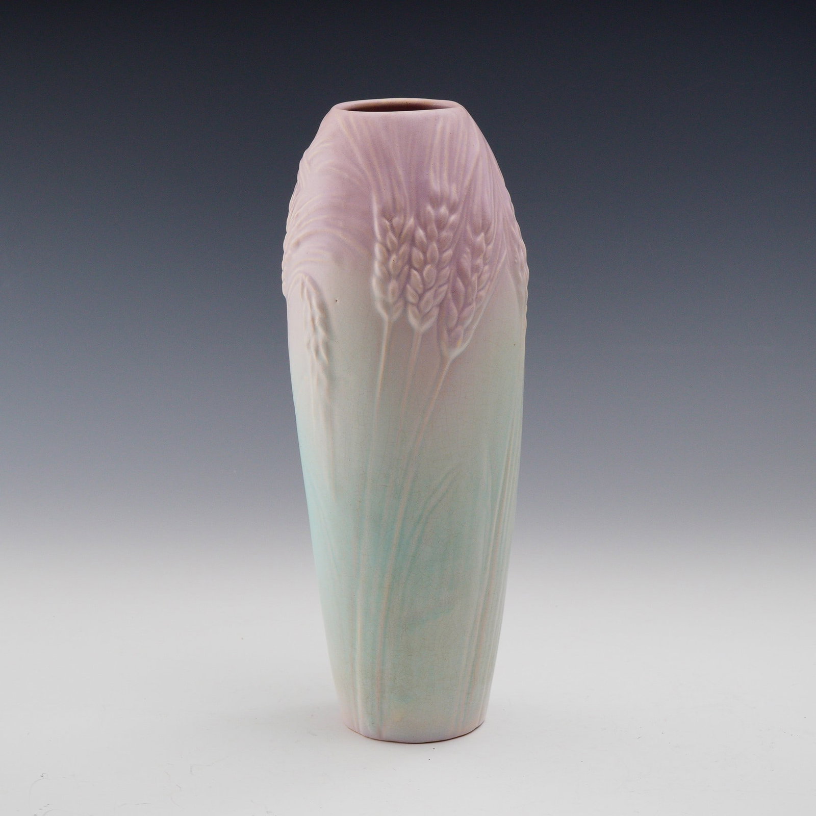 Weller Pottery Wheat Vase in Pastel Glaze: This exquisite Weller Pottery vase features a raised wheat design, symbolizing abundance and nature's beauty, presented in soft pastel shades of lavender and aqua. The matte finish accentuates the sub