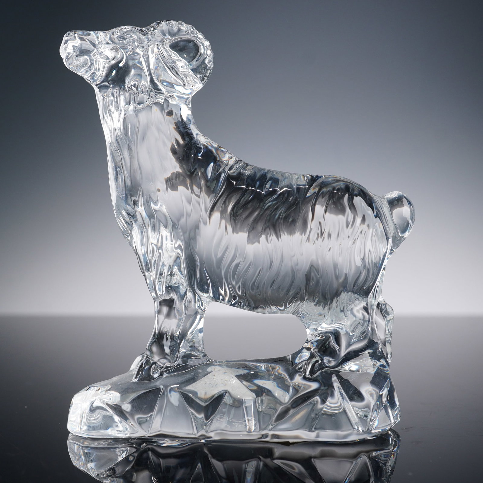 Baccarat Crystal Chinese Zodiac Animal Figurine, Ram: Baccarat crystal Chinese Zodiac figurine, Ram, featuring a clear crystal body with finely detailed fur texture and gracefully curved horns. The ram stands on a faceted crystal base, symbolizing streng