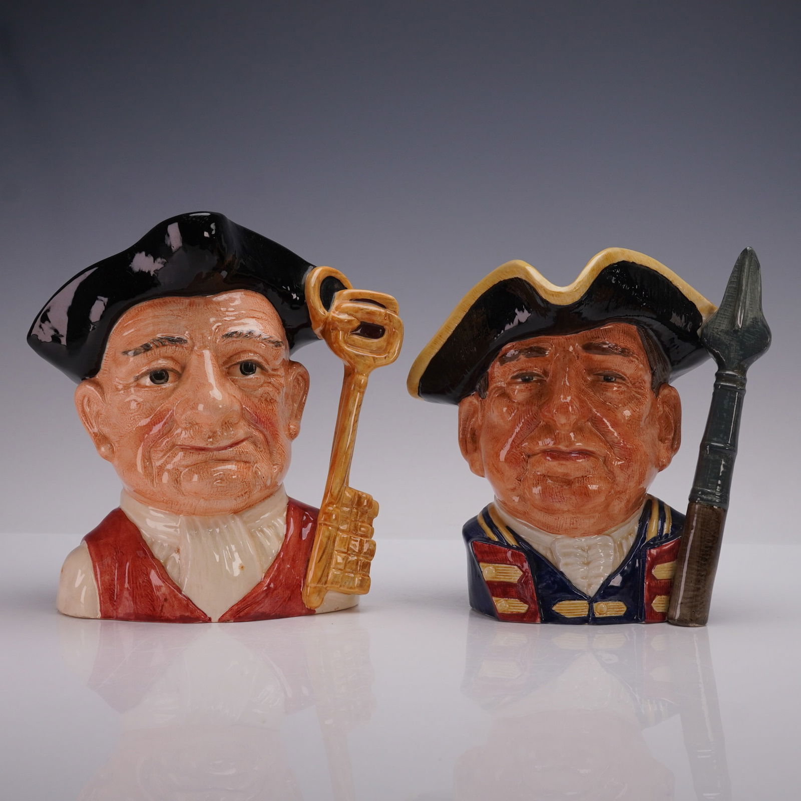 2pc Royal Doulton Large Character Jugs, Gaoler D6570 & Guardsman D6568: Pair of Royal Doulton large character jugs including Gaoler D6570, designed by David B. Biggs, featuring a tricorn hatted figure with a large key for a handle, and Guardsman of Williamsburg D6568, des