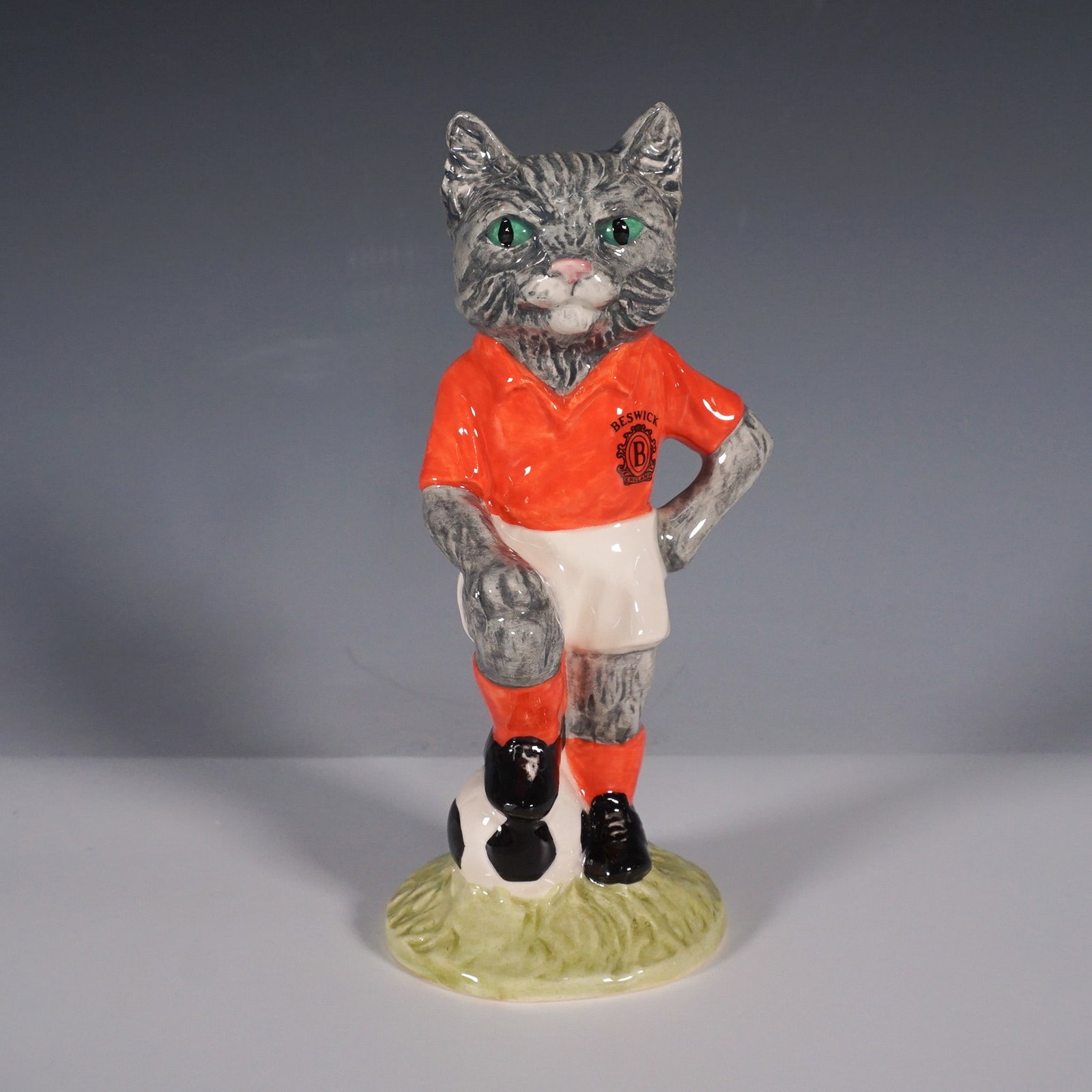Royal Doulton Footballing Felines Figurine, Model FF3 Kitcat with Box: This is a Royal Doulton Studios Footballing Felines model FF3 Kitcat, featuring a playful depiction of a feline in a soccer uniform. The piece is hand-painted and decorated, showcasing a footballer ca