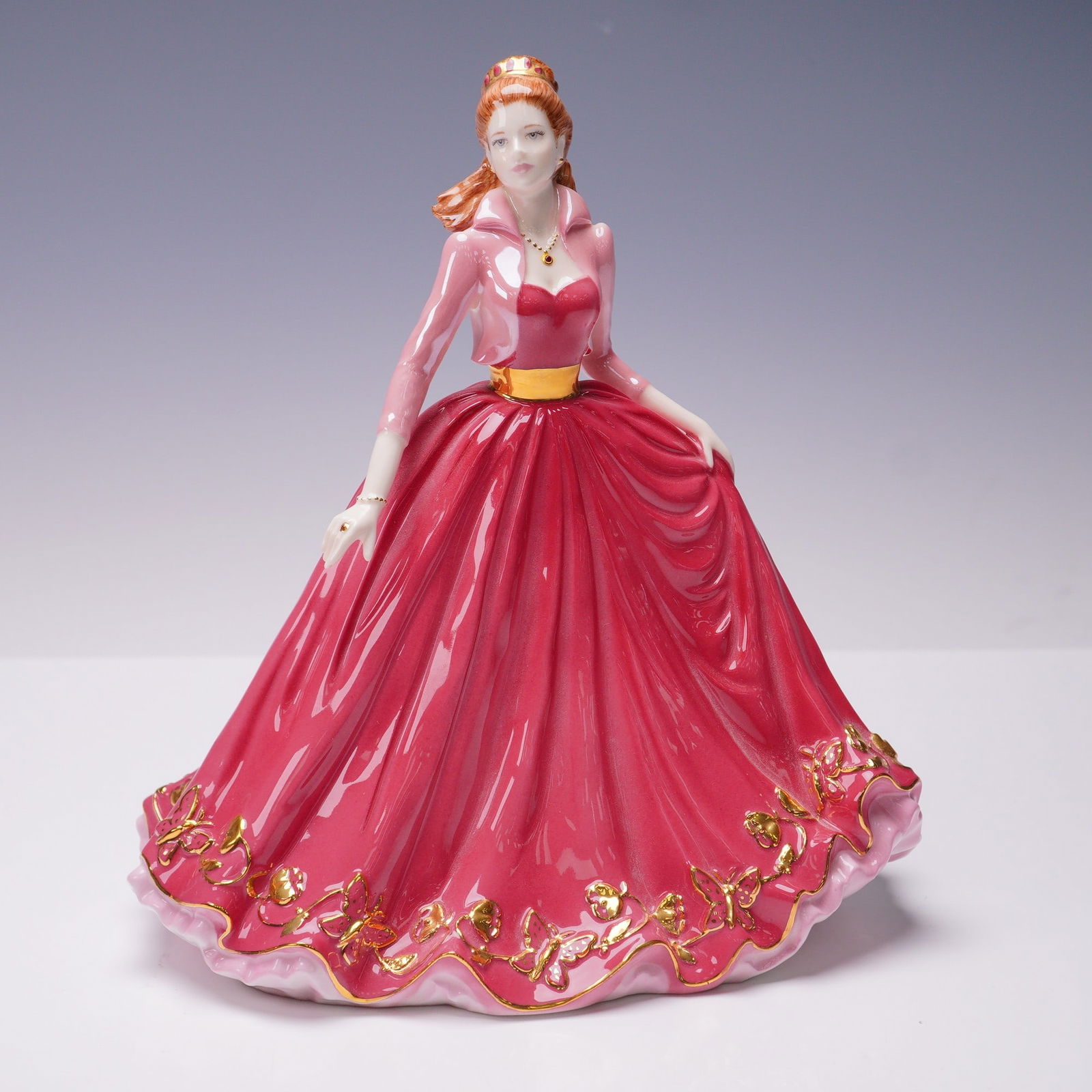 Coalport Figurine Ruby The Gem Collection: This Coalport bone china figurine titled Ruby is part of The Gem Collection and was released in 2004. She wears a stunning crimson gown adorned with gold floral detail and a matching necklace and brac