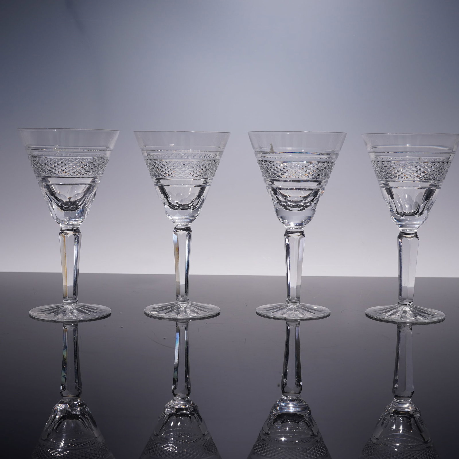4pc Waterford Rossmore Pattern Claret Wine Glasses: A set of four Waterford crystal claret wine glasses in the Rossmore pattern. Each glass features the diamond and crosscut design with a faceted stem, reflecting the refinement of Waterford's craftsman