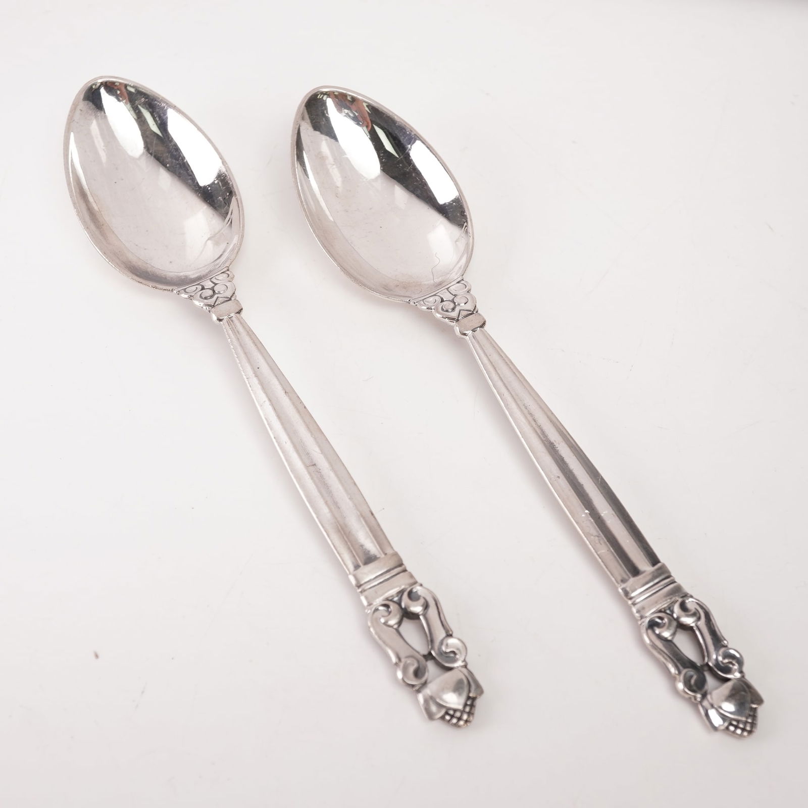 2pc Georg Jensen Sterling Silver Teaspoons, Acorn: A two-piece lot of Georg Jensen sterling silver teaspoons in the Acorn pattern, designed by Johan Rohde in 1915. Each marked Georg Jensen Sterling Denmark. The pattern features a fluted handle with sc