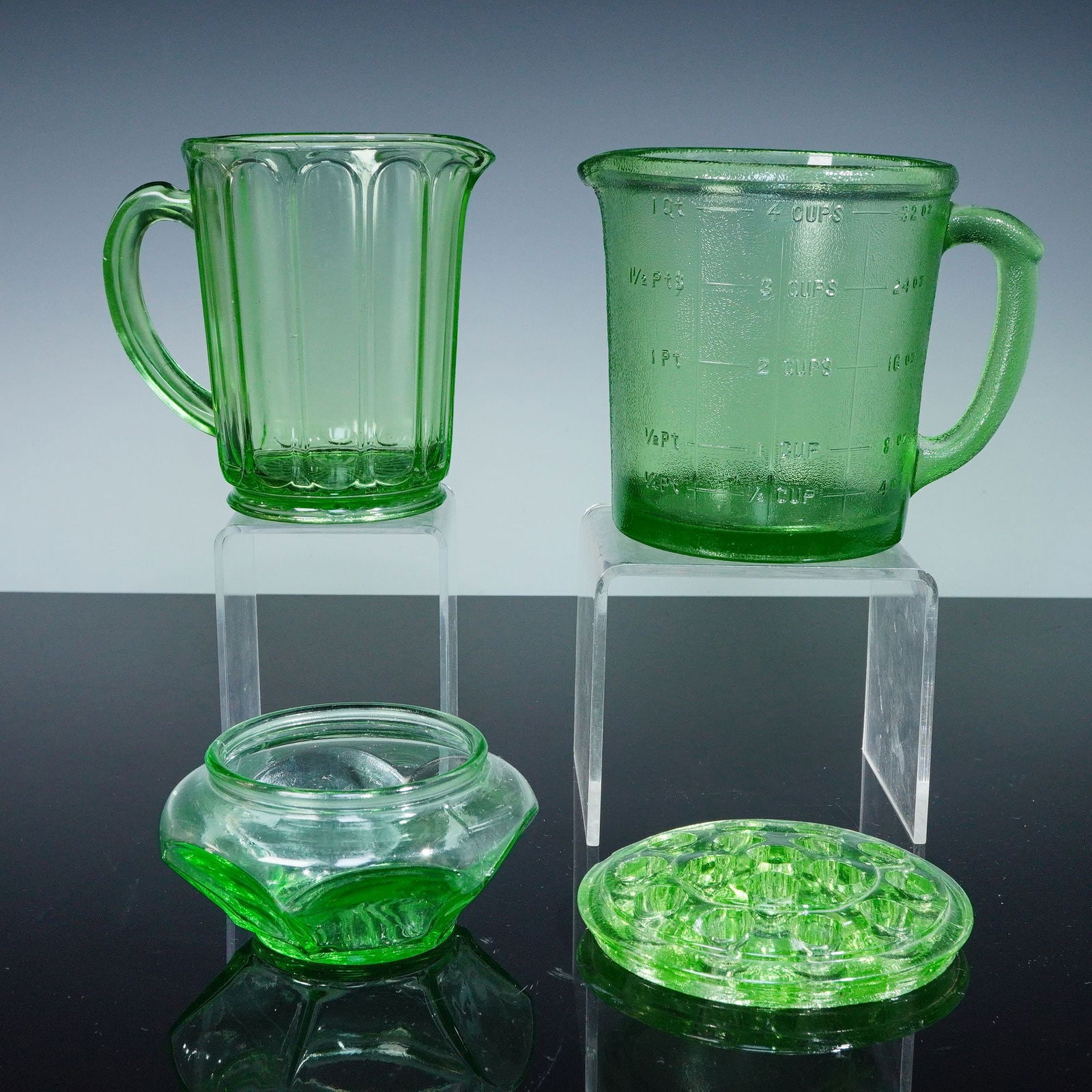 4pc Uranium Glass Set, 2 Pitchers, Flower Frog, and Bowl, Depression Glass: This vintage 4-piece set of uranium glass features two pitchers, a flower frog, and a bowl, all with the characteristic green glow under blacklight due to the uranium content. One pitcher has a heavil