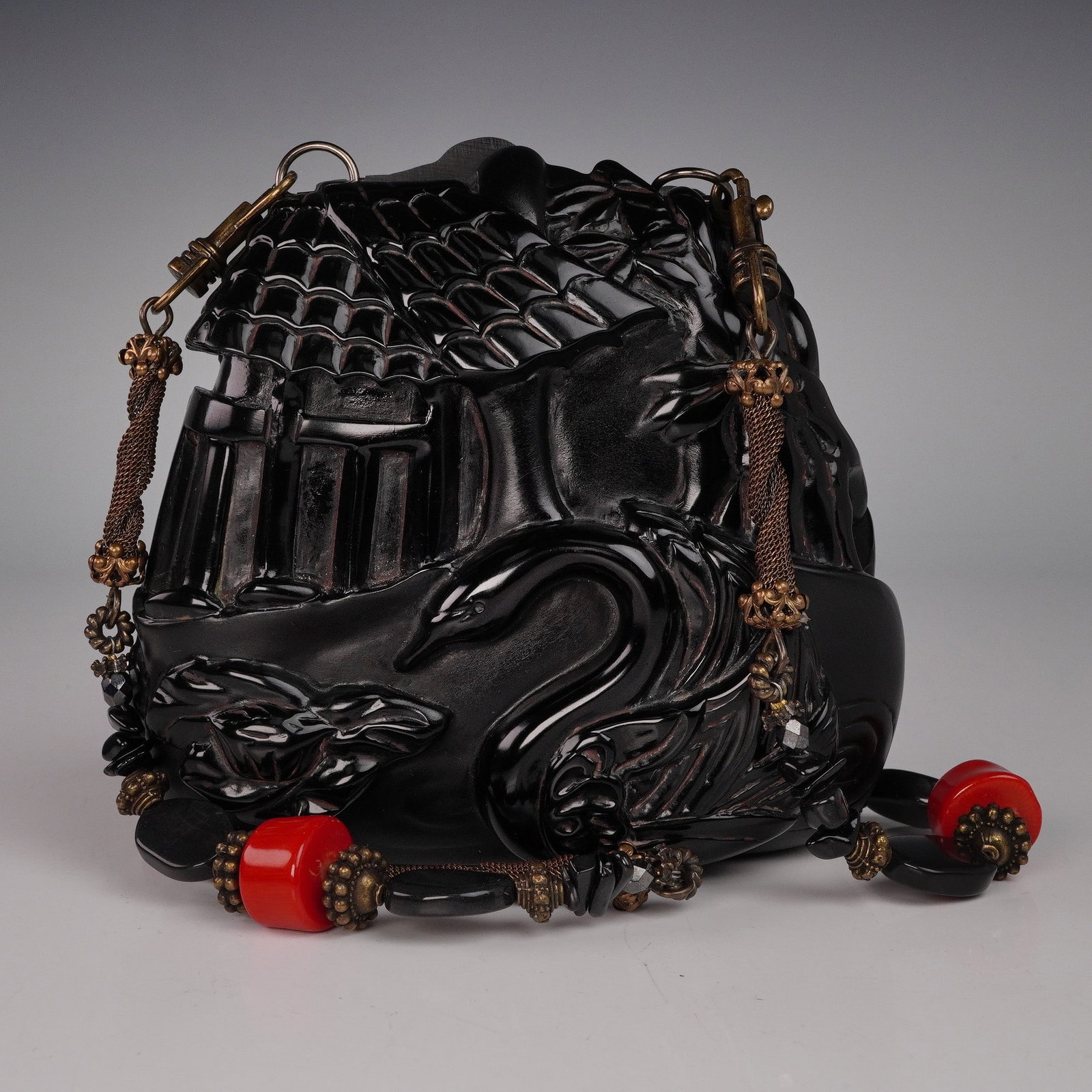 Vintage Maya Evangelista Black Resin Handbag with Metal and Stone Hardware: A striking vintage handbag by Maya Evangelista, crafted in black resin and deeply carved with a swan in front of a cottage with tiled roof and columns. The bag features decorative metal fittings and c