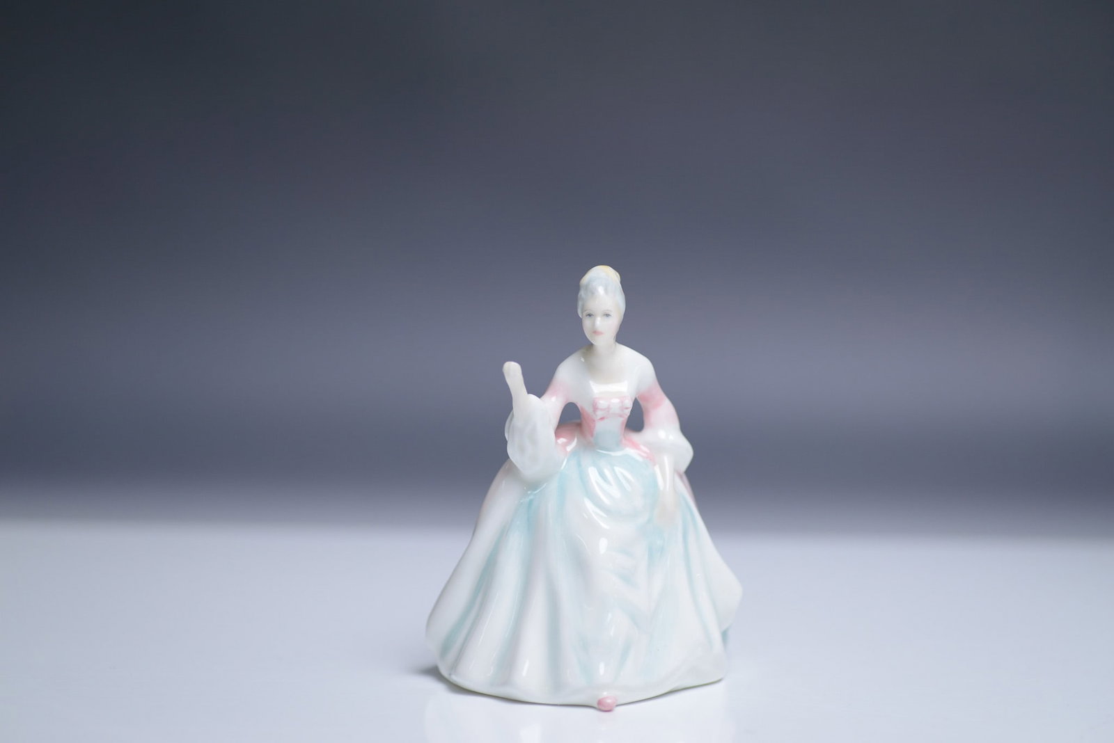 Royal Doulton Miniature Figurine, Diana HN 3310: A charming Royal Doulton miniature figurine titled Diana, model number HN 3310. This finely crafted bone china piece was designed by renowned artist Peggy Davies and issued in 1985. The figure depicts