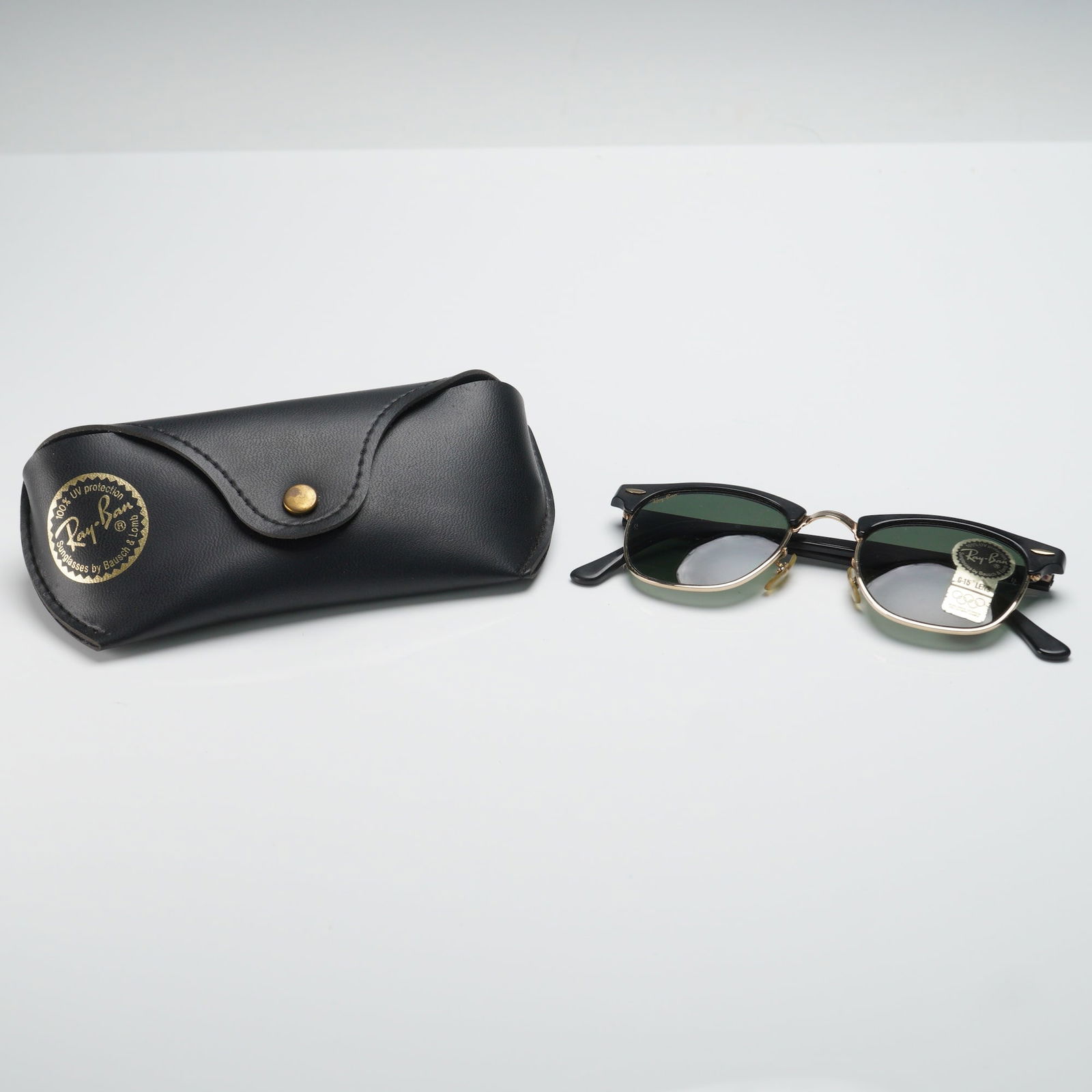 Vintage Ray-Ban Wayfarer Sunglasses Bausch & Lomb with Case: These vintage Ray-Ban Wayfarer sunglasses feature the classic black and gold frame, with G-15 lenses offering 100% UV protection. The frame is stamped with Bausch & Lomb Ray-Ban U.S.A., indicating the