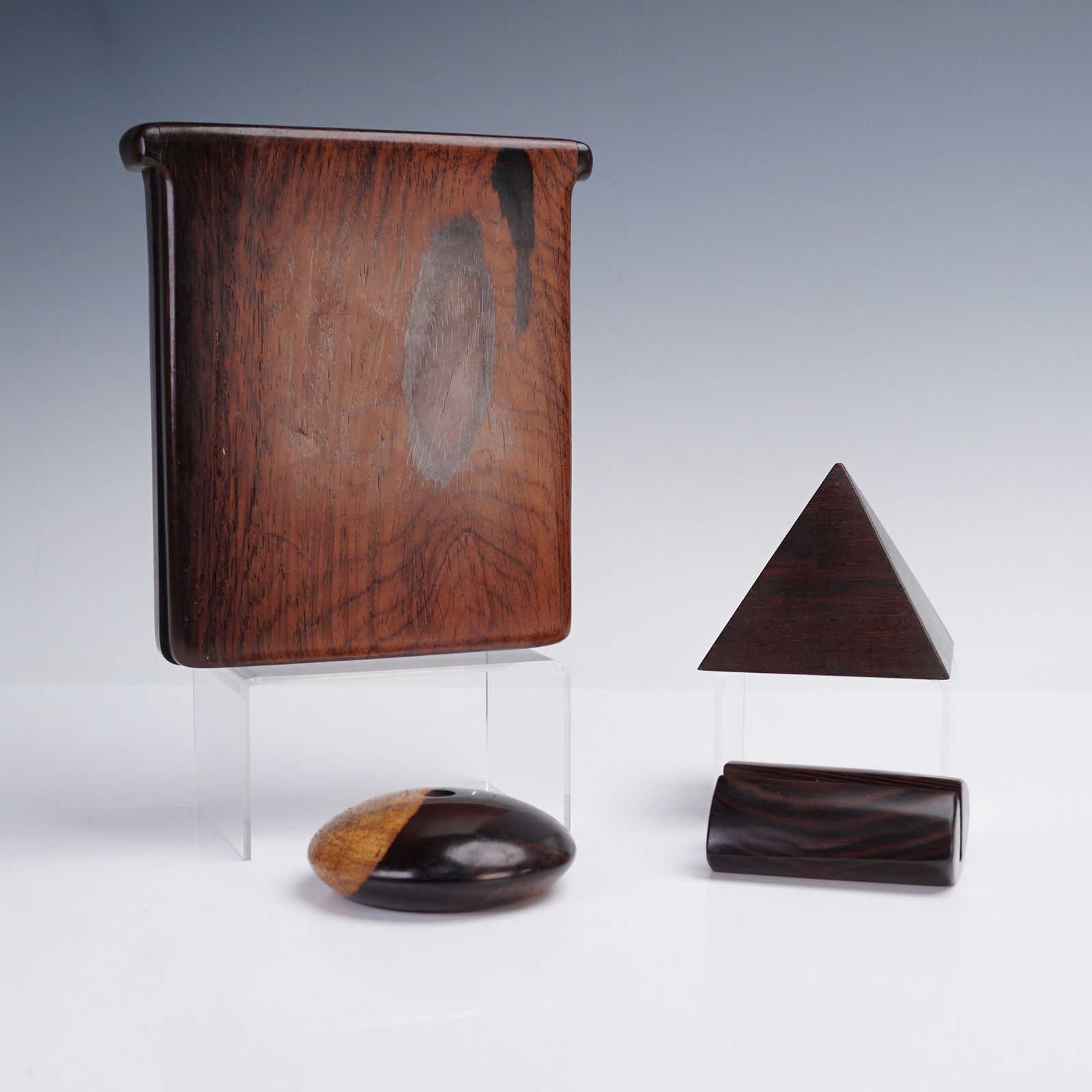 4pc Barry Biesanz Wooden Desk Accessories, Signed: A striking four-piece collection of finely crafted wood desk accessories by Barry Biesanz, renowned for his mastery in exotic tropical hardwoods. This set includes a geometric pyramid paperweight, a s