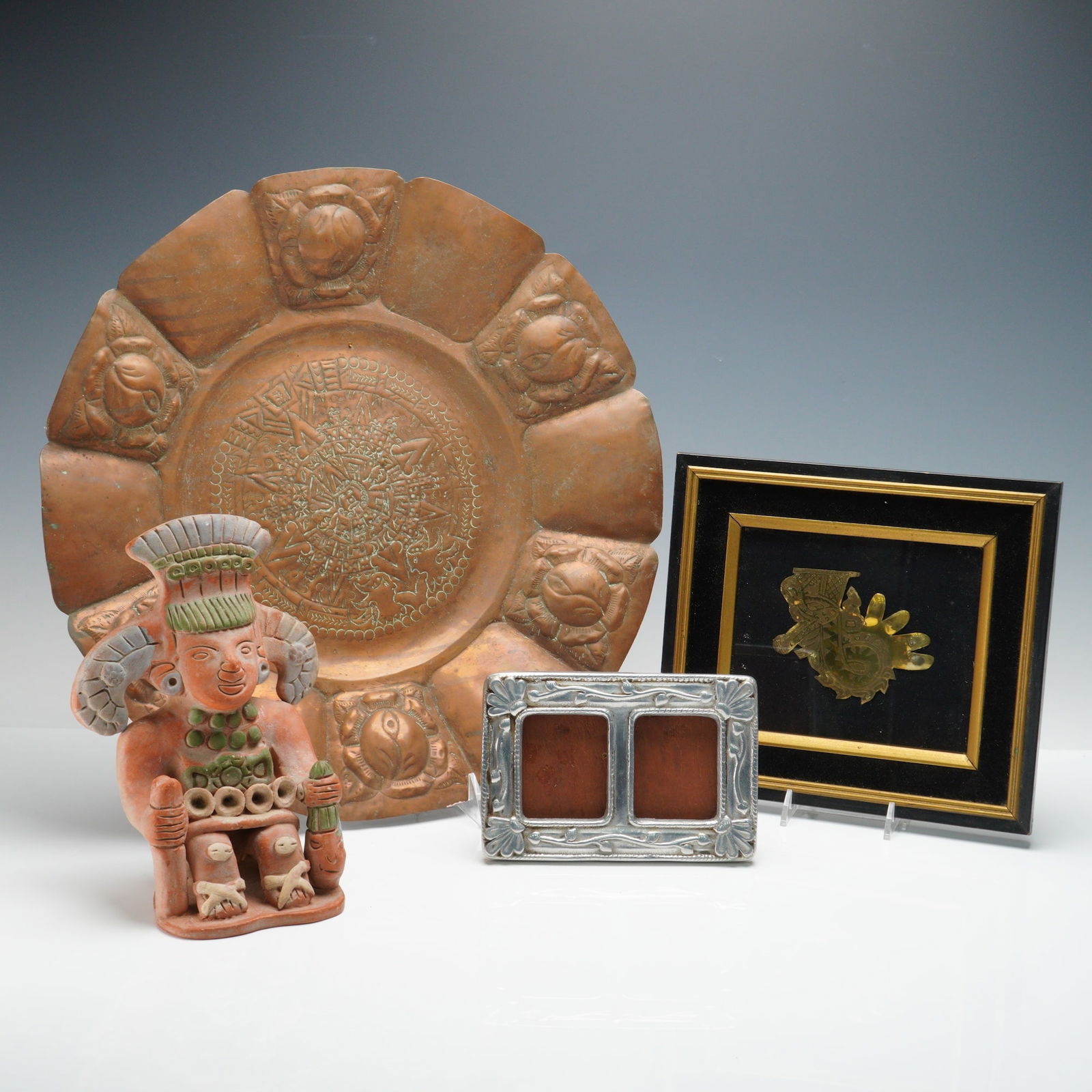 4pc Mexican Folk Art- Aztec Statue, Copper Plate, Framed Picture & Frame: A four piece group of Mexican hand-crafted art and decorative objects. The terracotta Aztec-style statue is designed as a seated figure with elaborate headdress and functional opening at the back, lik