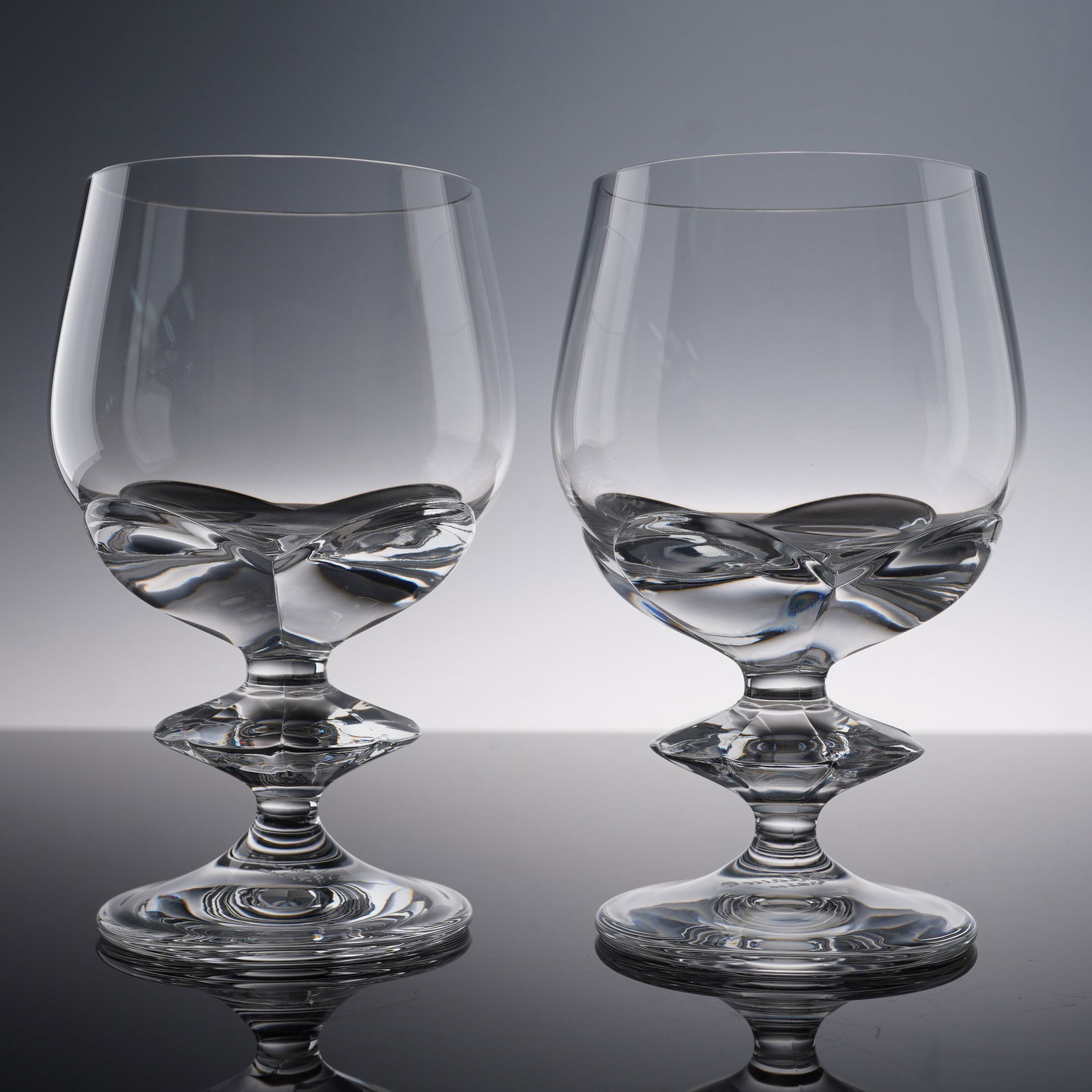 Pair of Lalique Crystal Sherry Glasses, Blois: From the personal estate of Marie-Claude Lalique. Set of two clear crystal sherry glasses, each designed with a smooth bowl and a distinctive wafer-style stem. The underside of both glasses is etched 