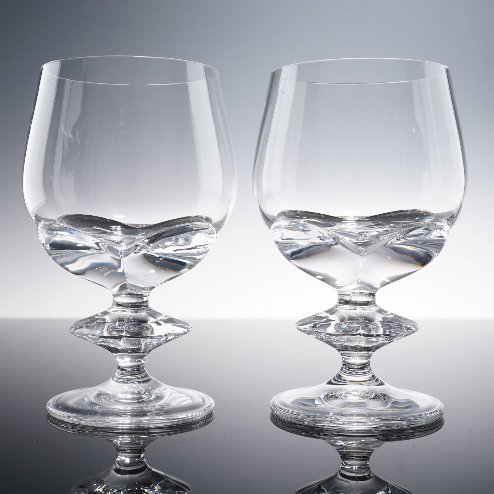Pair of Lalique Crystal Sherry Glasses, Blois: Previously from the estate of Marie-Claude Lalique. Set of two crystal sherry glasses, each glass is crafted in clear crystal with a distinctive wafer stem and smooth bowl. The underside of each piece