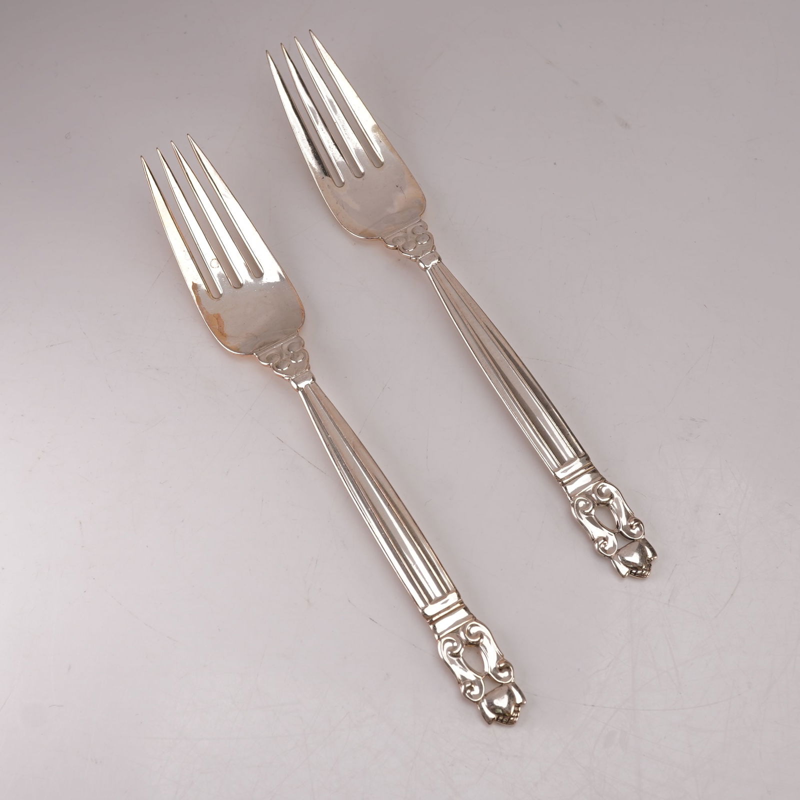 2pc Georg Jensen Sterling Silver Luncheon Forks, Acorn: A two piece lot of Georg Jensen sterling silver luncheon forks in the Acorn pattern, designed by Johan Rohde. Each bears the Georg Jensen hallmark and is stamped Sterling Denmark. The pattern features