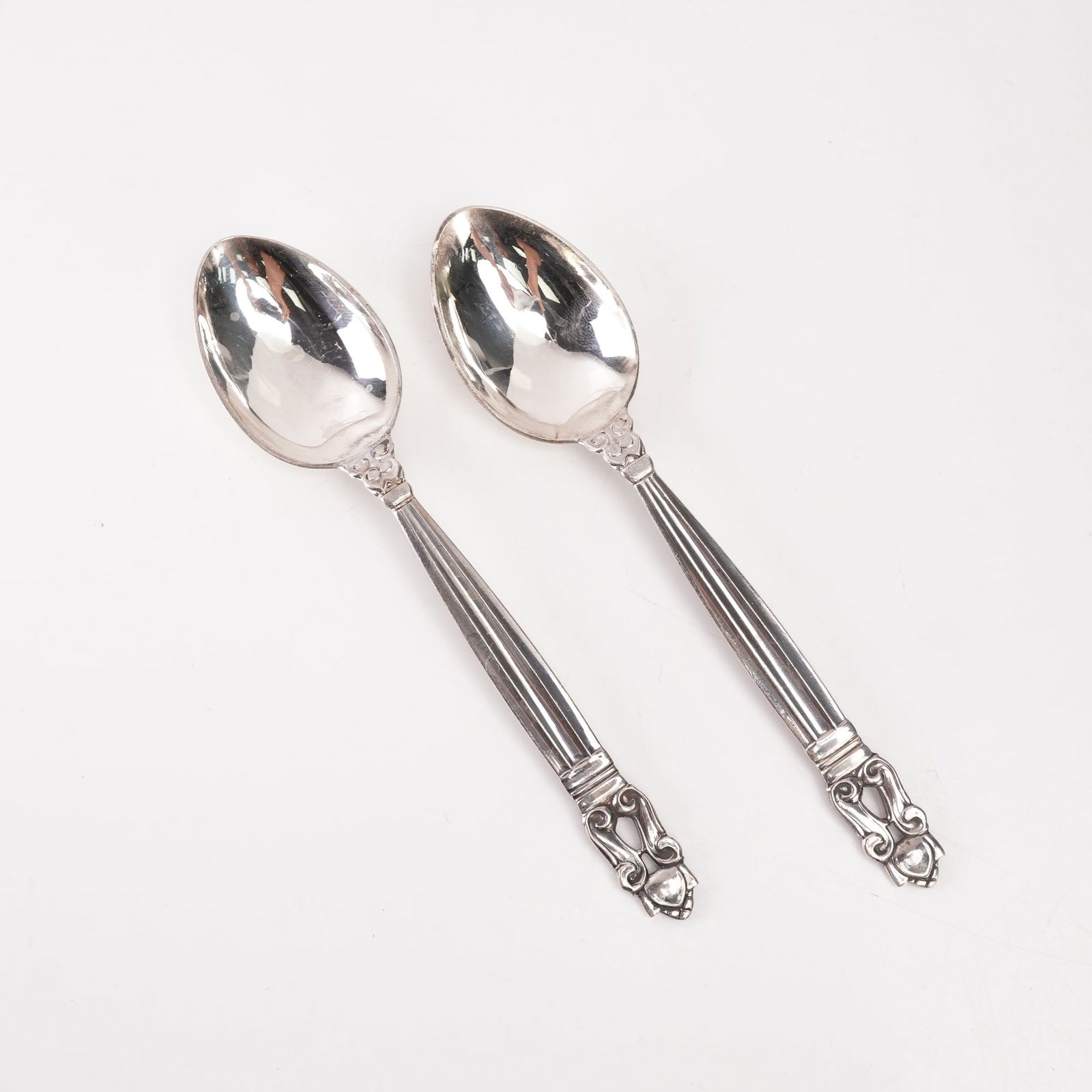2pc Georg Jensen Sterling Silver Fruit Spoons, Acorn: Pair of Georg Jensen sterling silver fruit spoons in the Acorn pattern, designed by Johan Rohde and introduced in 1915. Each spoon features a gently rounded bowl and a tapered handle with fluted lines