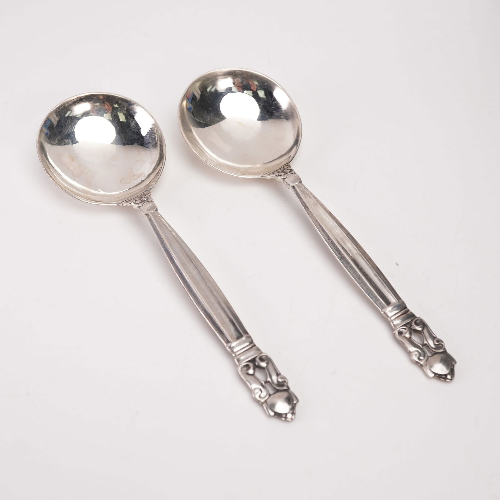 2pc Georg Jensen Sterling Silver Round Bowl Soup Spoons, Acorn: A two-piece lot of Georg Jensen sterling silver round bowl soup spoons in the Acorn pattern, designed by Johan Rohde in 1915. Each marked Georg Jensen Sterling Denmark. The pattern features a tapered,