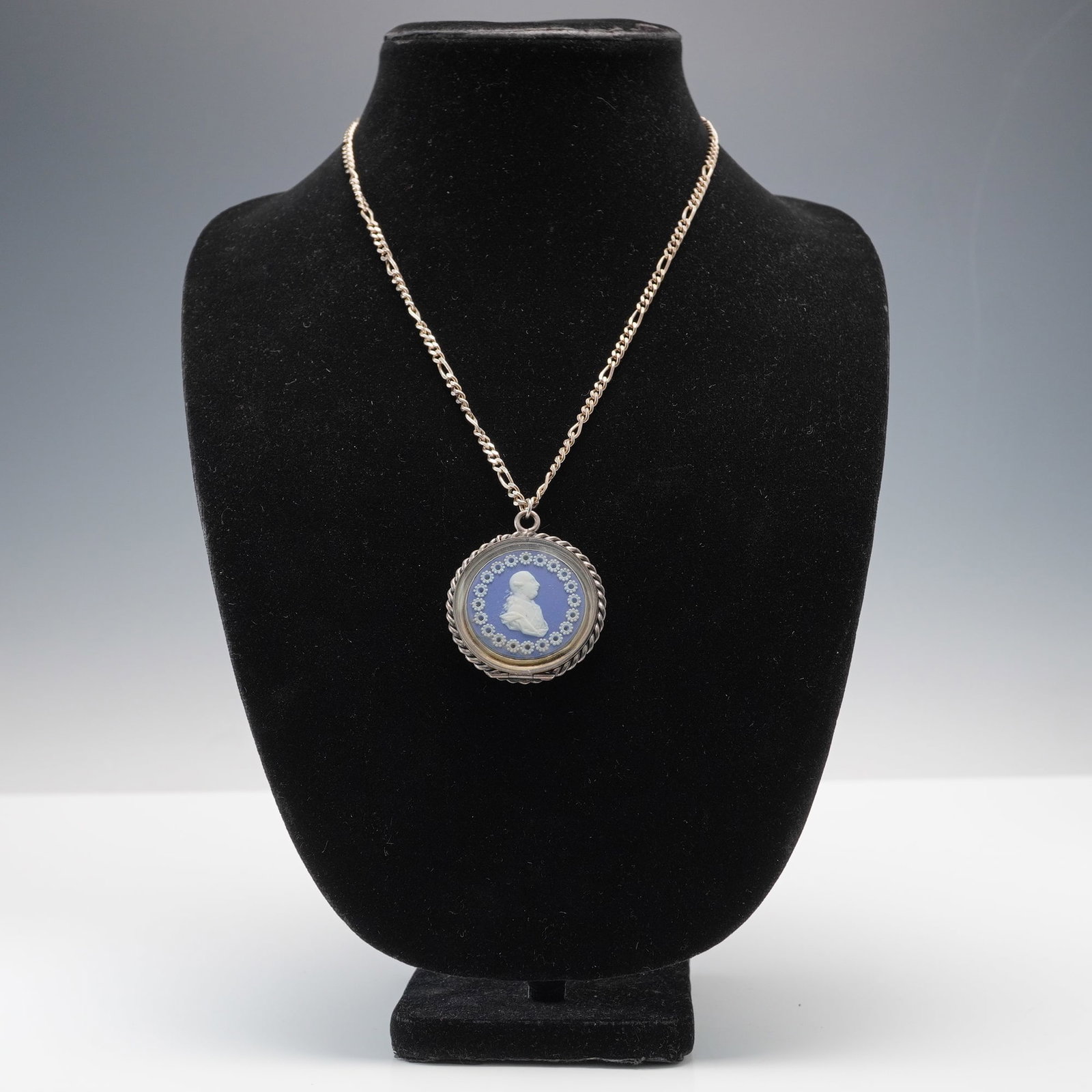 Wedgwood Blue Jasperware Portrait of Comte de Mirabou Medallion Necklace: Featuring a white relief bust of Comte de Mirabeau on a solid blue jasper ground, surrounded by a ring of raised floral motifs. The oval pendant is mounted in a twisted sterling silver frame marked St