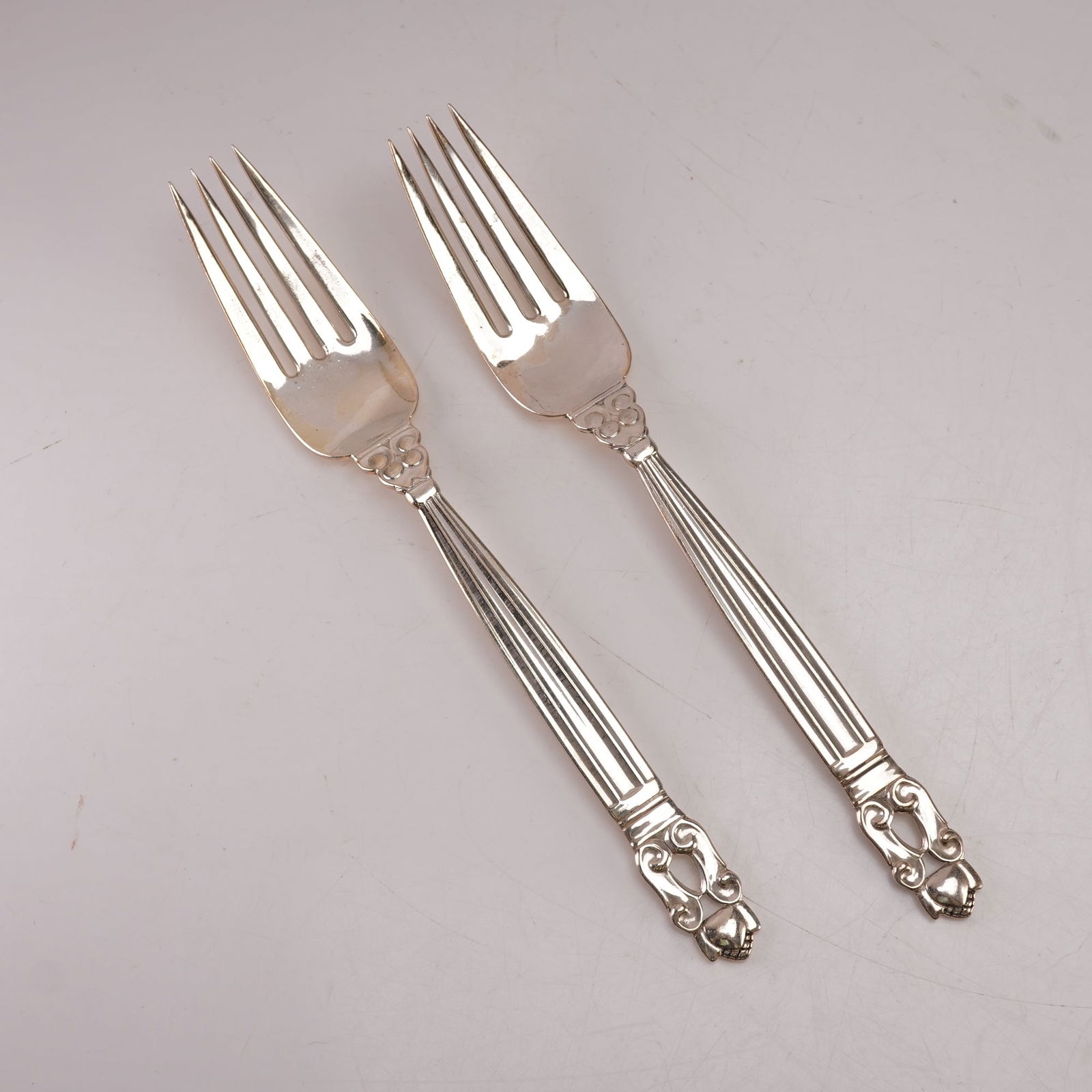 2pc Georg Jensen Sterling Silver Luncheon Forks, Acorn: A two piece lot of Georg Jensen sterling silver luncheon forks in the Acorn pattern, designed by Johan Rohde. Each bears the Georg Jensen hallmark and is stamped Sterling Denmark. The pattern features