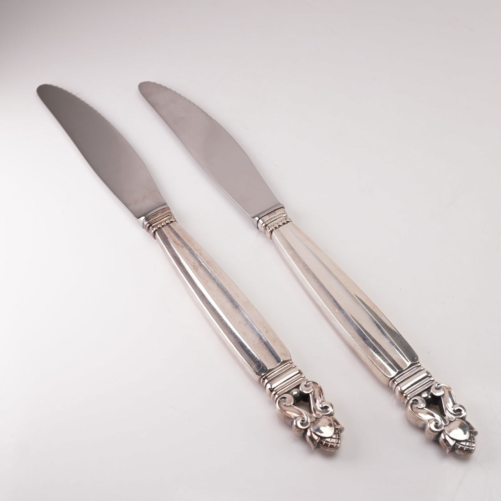 2pc Georg Jensen Sterling Silver Stainless Steel Dinner Knives, Acorn: A two-piece lot of Georg Jensen dinner knives in the Acorn pattern, designed by Johan Rohde in 1915. Each knife features a sterling silver handle marked Sterling Denmark with the Georg Jensen hallmark