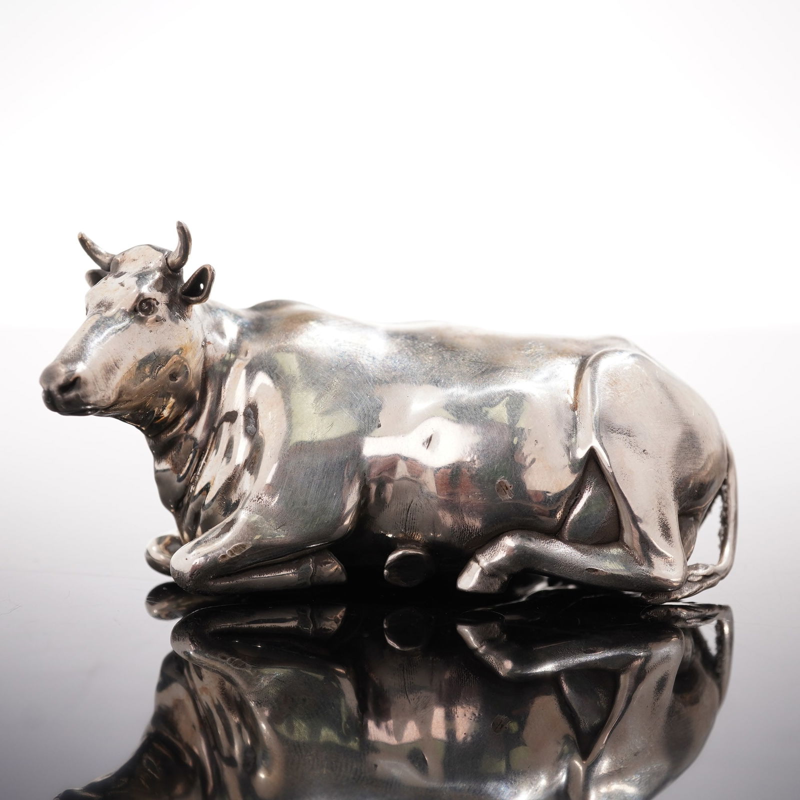 Russian 84 Silver Reclining Cow with Diamond Eyes: An exquisite Russian 84 silver sculpture of a reclining cow, masterfully rendered in lifelike detail. The piece features finely modeled musculature, expressive facial features, and brilliant diamond e