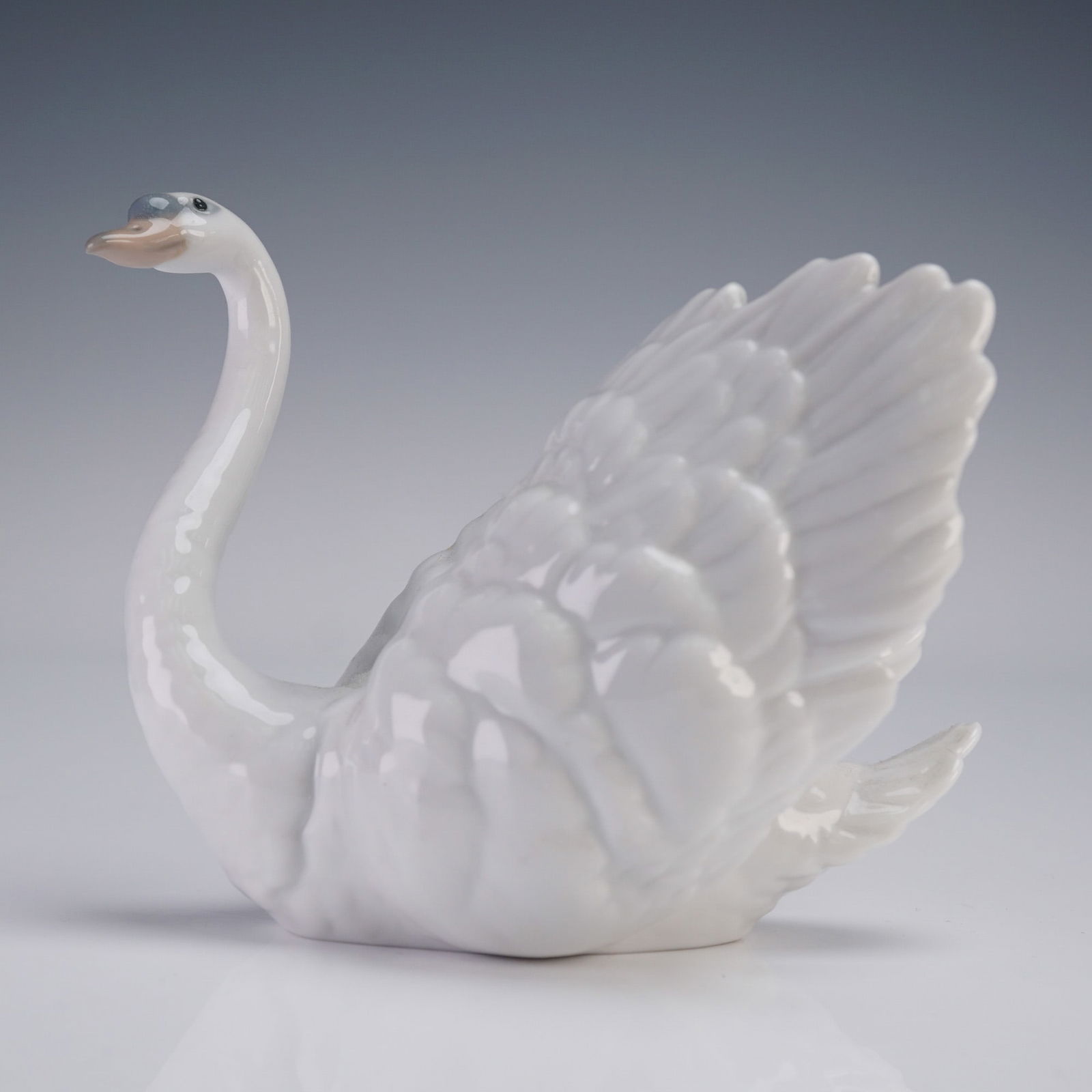 Lladro Porcelain Figurine, White Swan 1006175: Lladro porcelain figurine titled White Swan, Cisne Galante, sculpted by Regino Torrijos. Issued in 1995 and retired in 2010. The piece depicts a graceful swan with wings partially raised, finished in