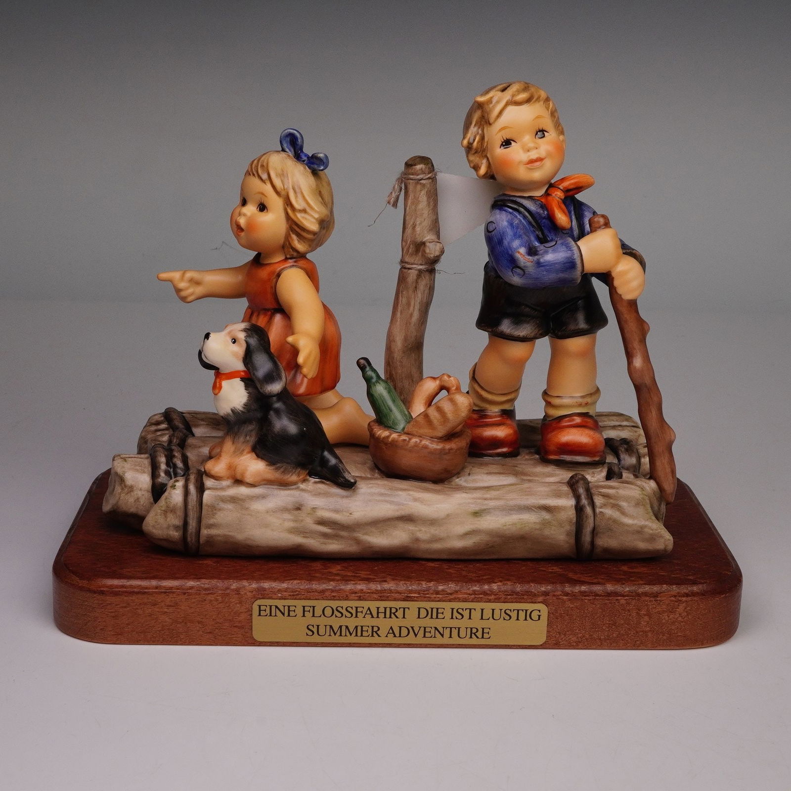 Goebel Hummel Figurine with Base, Summer Adventure: M.I. Hummel figurine titled Summer Adventure, depicting two children on a wooden raft with a dog, basket, and sail, mounted on a wooden base with title plaque. Includes original certificate and presen