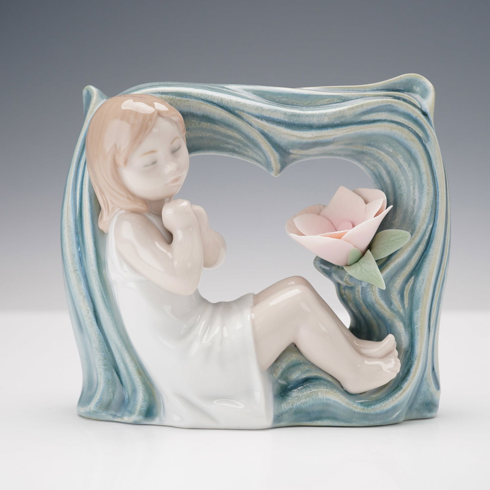 Lladro Porcelain Figurine Childhood Fantasy 1008130: This Lladro porcelain figurine, model number 1008130, titled Childhood Fantasy, depicts a young girl seated next to a flower. The entire piece, crafted in soft pastel tones, has a glossy finish, while