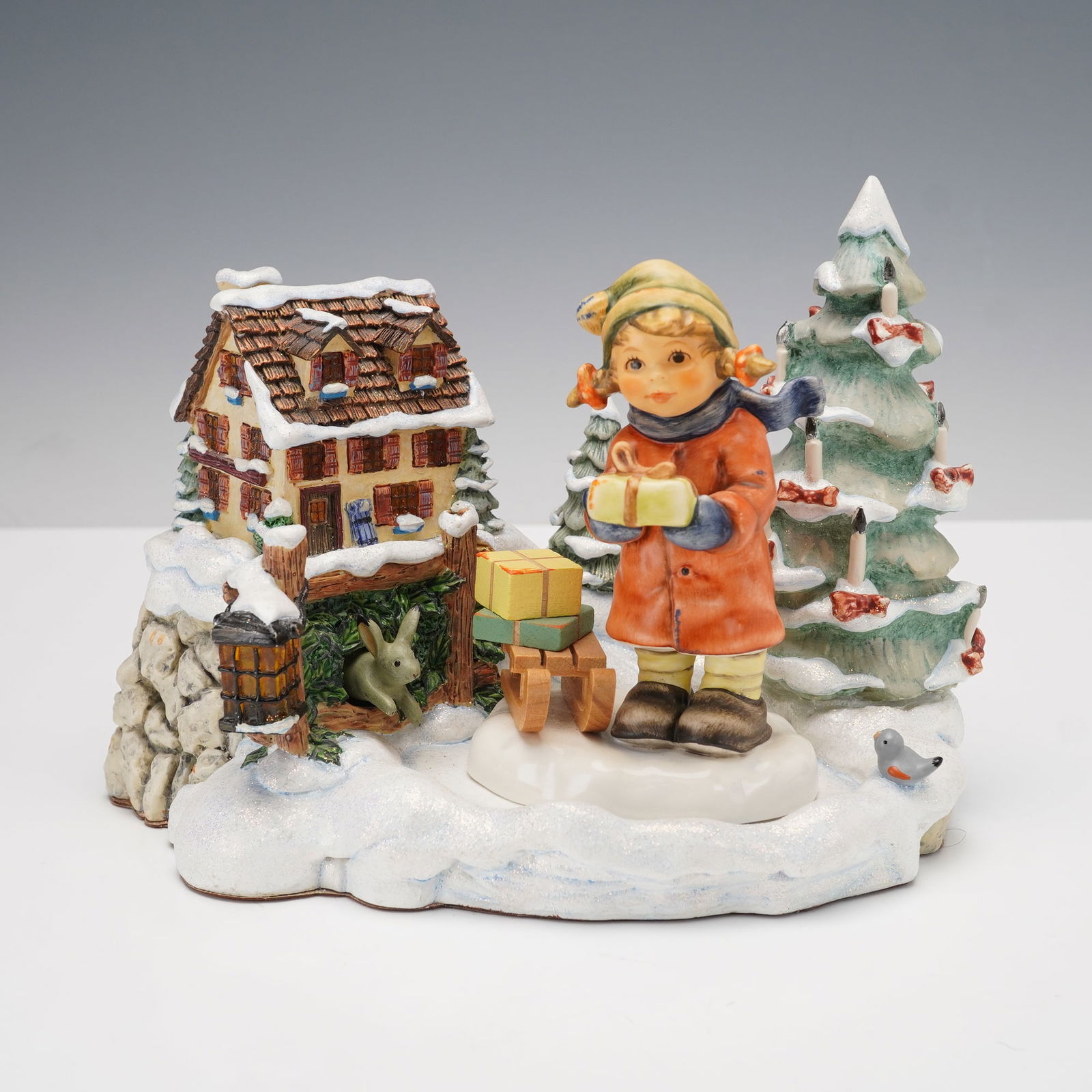 2pc Goebel Hummel Tidings of Joy Music Base & Good Tiding Figurine: Charming 2-piece Goebel M.I. Hummel porcelain set featuring the Good Tiding figurine paired with the Tidings of Joy musical display base. The hand-painted figurine depicts a young girl in a red coat a