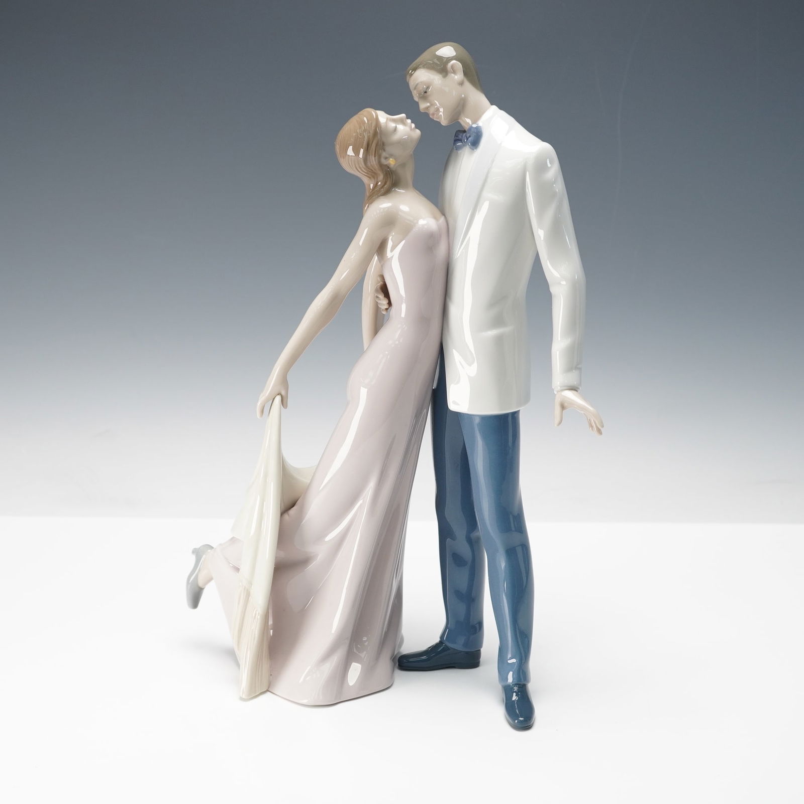 Lladro Porcelain Figurine, Happy Anniversary 1006475: Glossy porcelain figurine titled Happy Anniversary or Feliz Aniversario, sculpted by Jose Puche and issued in 1998, depicting an elegant embracing couple. Classic pastel tones and graceful movement sh