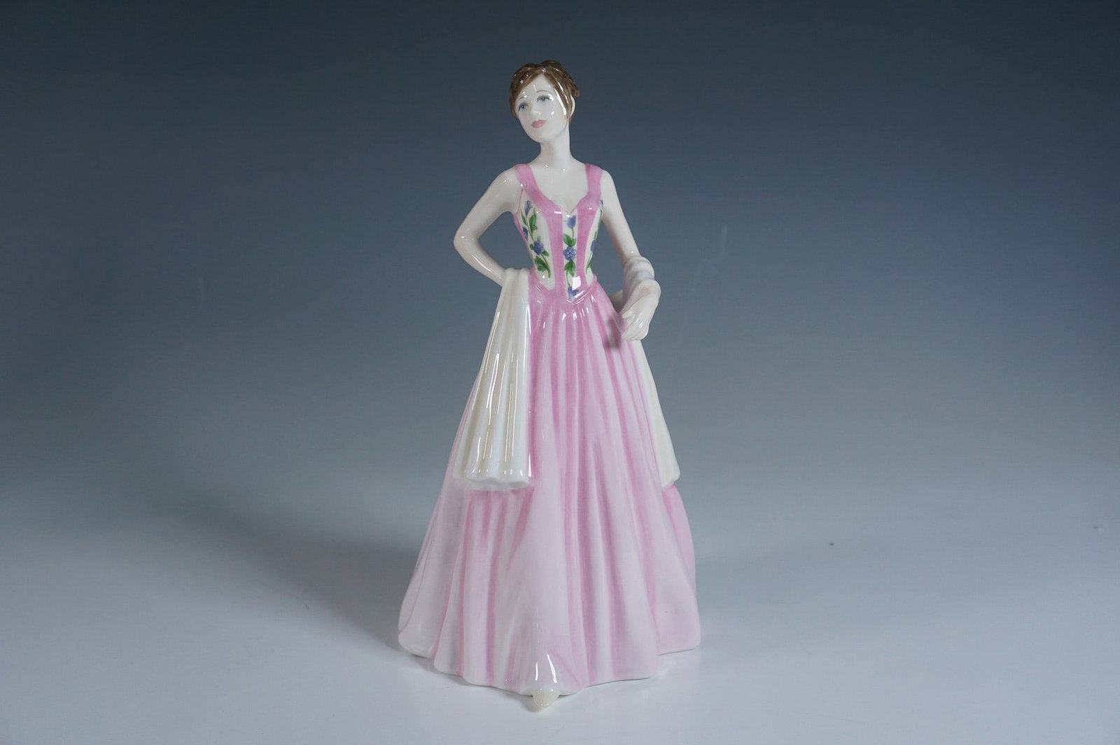 Royal Doulton Figurine, April HN4520: Royal Doulton Classics fine bone china figurine titled April, model HN4520. Designed by Nada Pedley, this elegant figurine features a young woman in a flowing pink gown with floral detailing on the bo