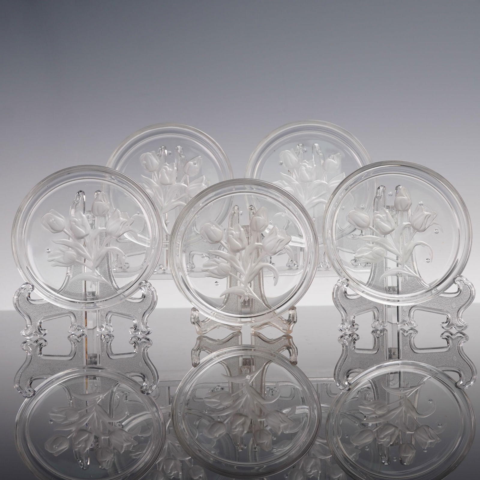 5pc Val Saint Lambert Floral Intaglio Glass Coasters: A set of five round glass coasters by Val Saint Lambert, each decorated with a frosted intaglio tulip design. The refined floral motif reflects the craftsmanship of this renowned Belgian glassworks, m