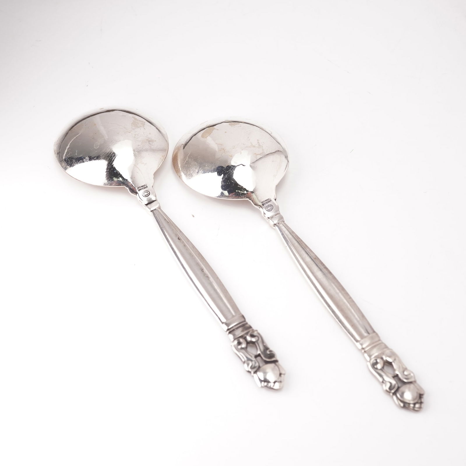 2pc Georg Jensen Sterling Silver Round Bowl Soup Spoons, Acorn: A two-piece lot of Georg Jensen sterling silver round bowl soup spoons in the Acorn pattern, designed by Johan Rohde in 1915. Each marked Georg Jensen Sterling Denmark. The pattern features a tapered,