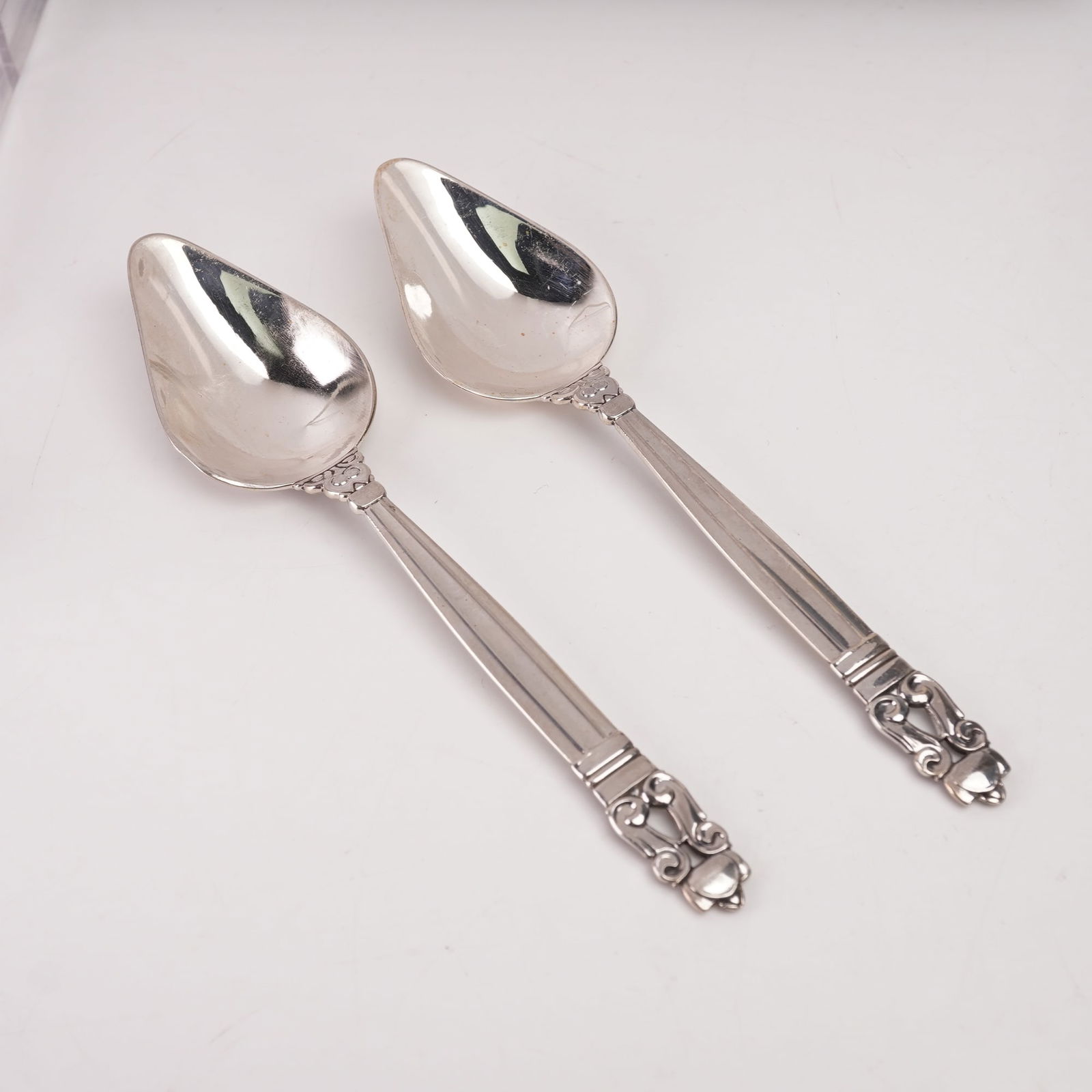 2pc Georg Jensen Sterling Silver Grapefruit Spoons, Acorn: This elegant two-piece set of Georg Jensen sterling silver grapefruit spoons features the renowned Acorn pattern, originally designed in 1915 by Johan Rohde. Each spoon displays the distinctive teardr