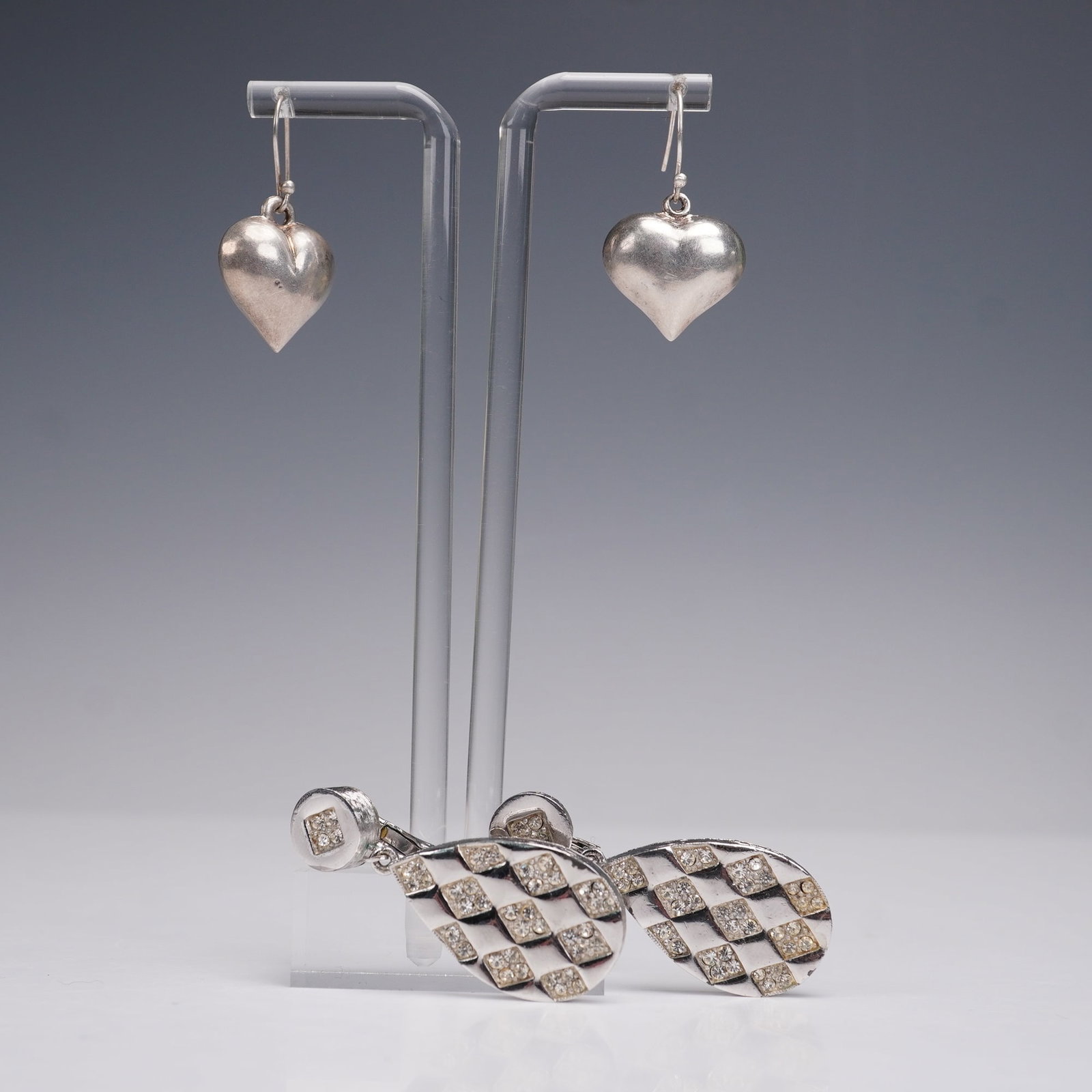 2 Pairs of Drop Earrings, Silver Hearts and Rhinestone: A two-pair lot of earrings including one pair of silver heart-shaped drop earrings with softly domed forms and a classic polished finish. The second pair is marked Eisenberg, designed as silver-tone t