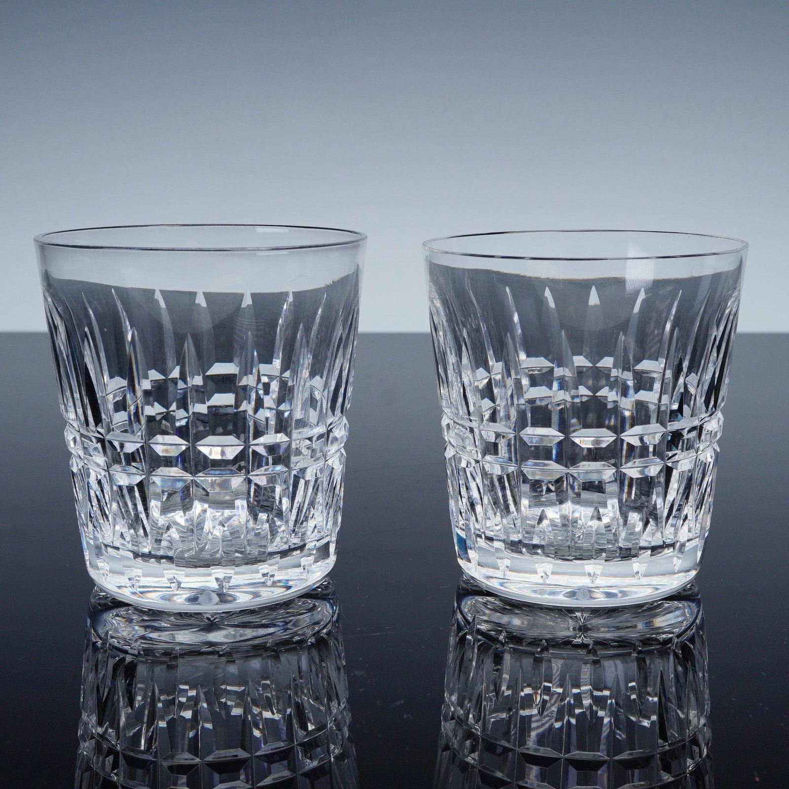 Pair of Waterford Glenmore Crystal Old Fashioned Glasses: Finely crafted with brilliant faceted cuts that catch and reflect the light with elegance. The design features vertical and diamond cut panels accented by a band of intricate cross-cutting around the 