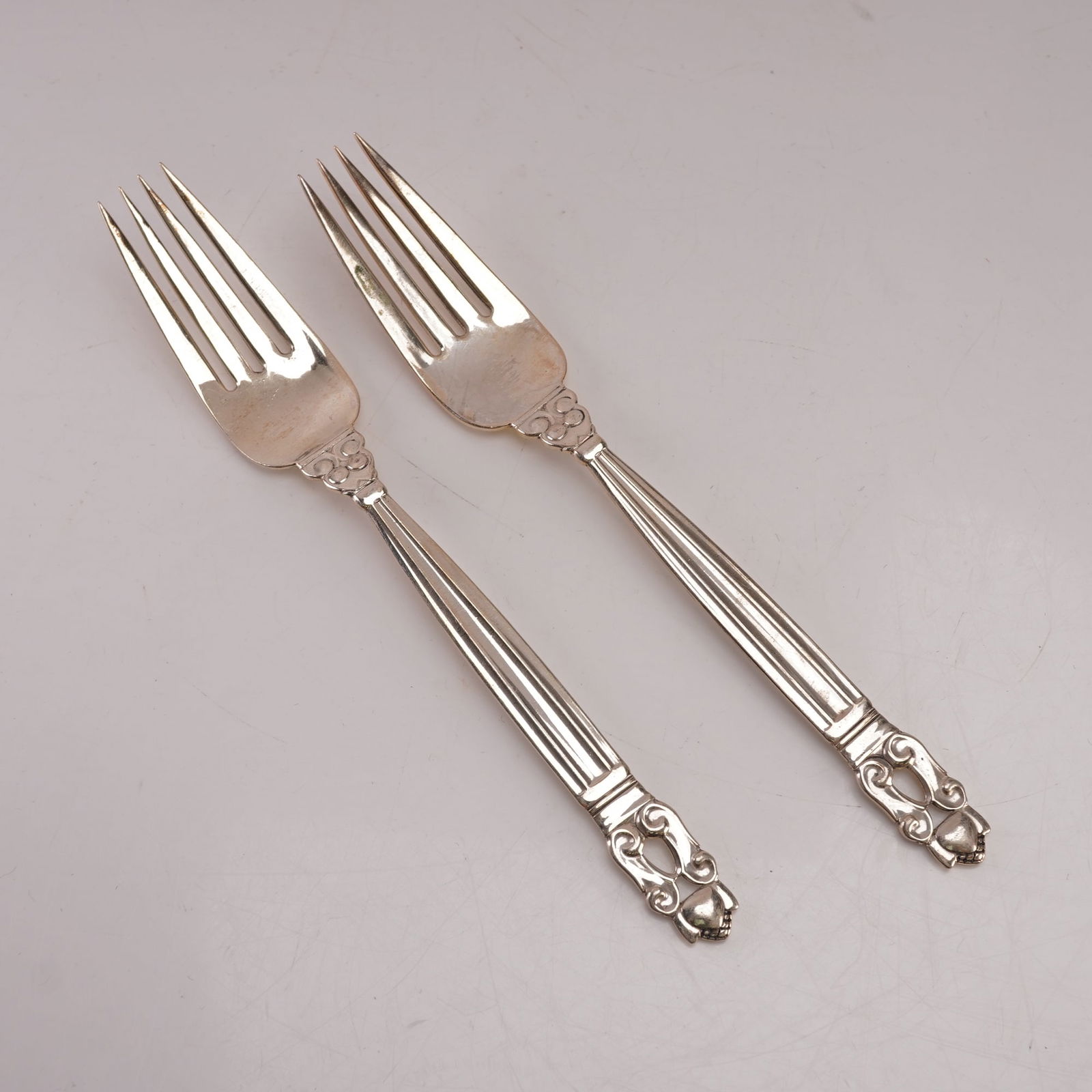 2pc Georg Jensen Sterling Silver Luncheon Forks, Acorn: A two piece lot of Georg Jensen sterling silver luncheon forks in the Acorn pattern, designed by Johan Rohde. Each bears the Georg Jensen hallmark and is stamped Sterling Denmark. The pattern features