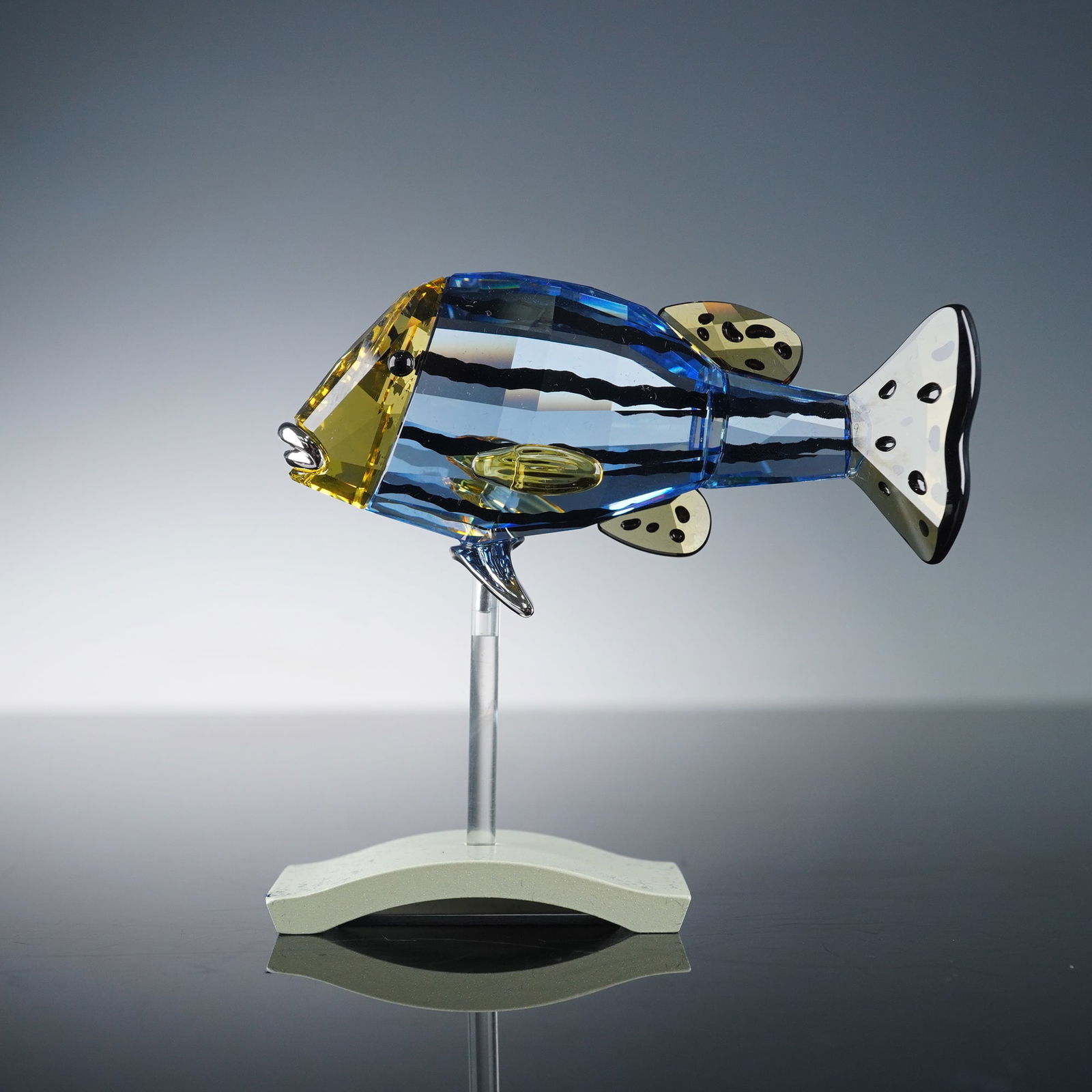 Swarovski Crystal Figurine, Paradise Fish - Catumbela: Vibrant Swarovski Crystal Paradise Collection Catumbela Fish designed by Yasmine Hurel. This striking figurine features a bold combination of blue, yellow, and clear crystal accented with jet-black en