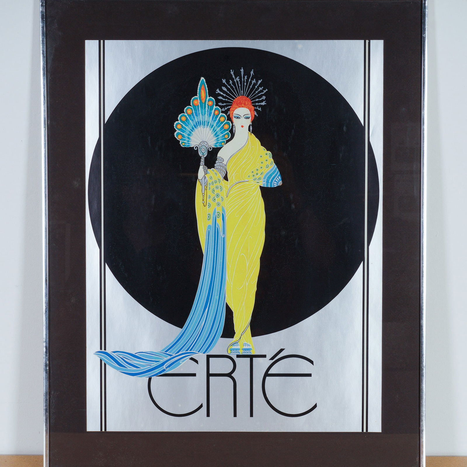 Erte, Art Deco Poster, Goddess in Yellow: This striking Art Deco poster by Erte, titled Goddess in Yellow, captures the artist's hallmark elegance and theatrical flair. Depicting a poised woman draped in a flowing yellow gown accented with tu