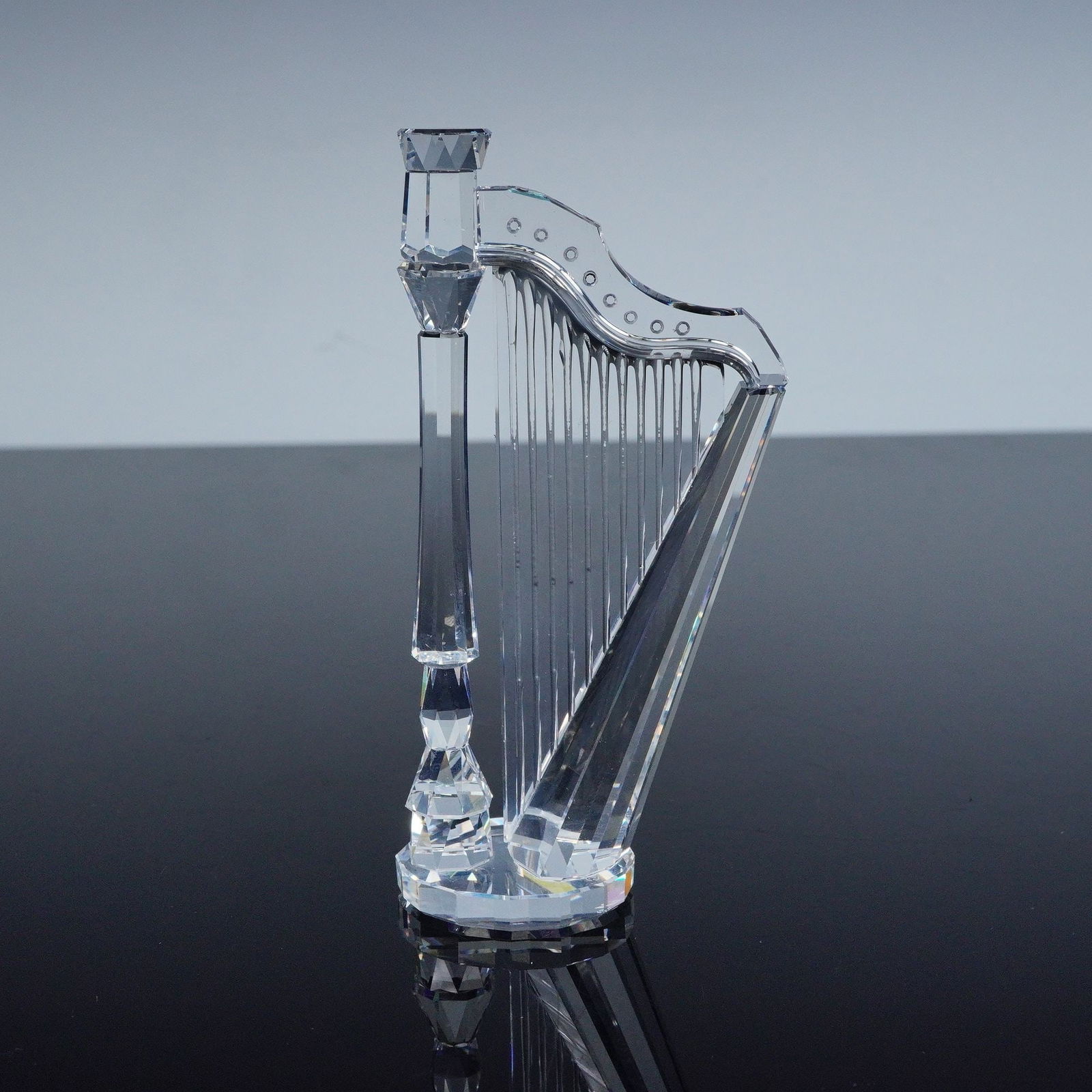 Swarovski Crystal Figurine, Harp: Swarovski Harp 169245 figurine crafted in clear crystal with elegant faceted detail, bearing the Swarovski backstamp, includes original box 6.25"H. A refined musical accent that showcases the brand's
