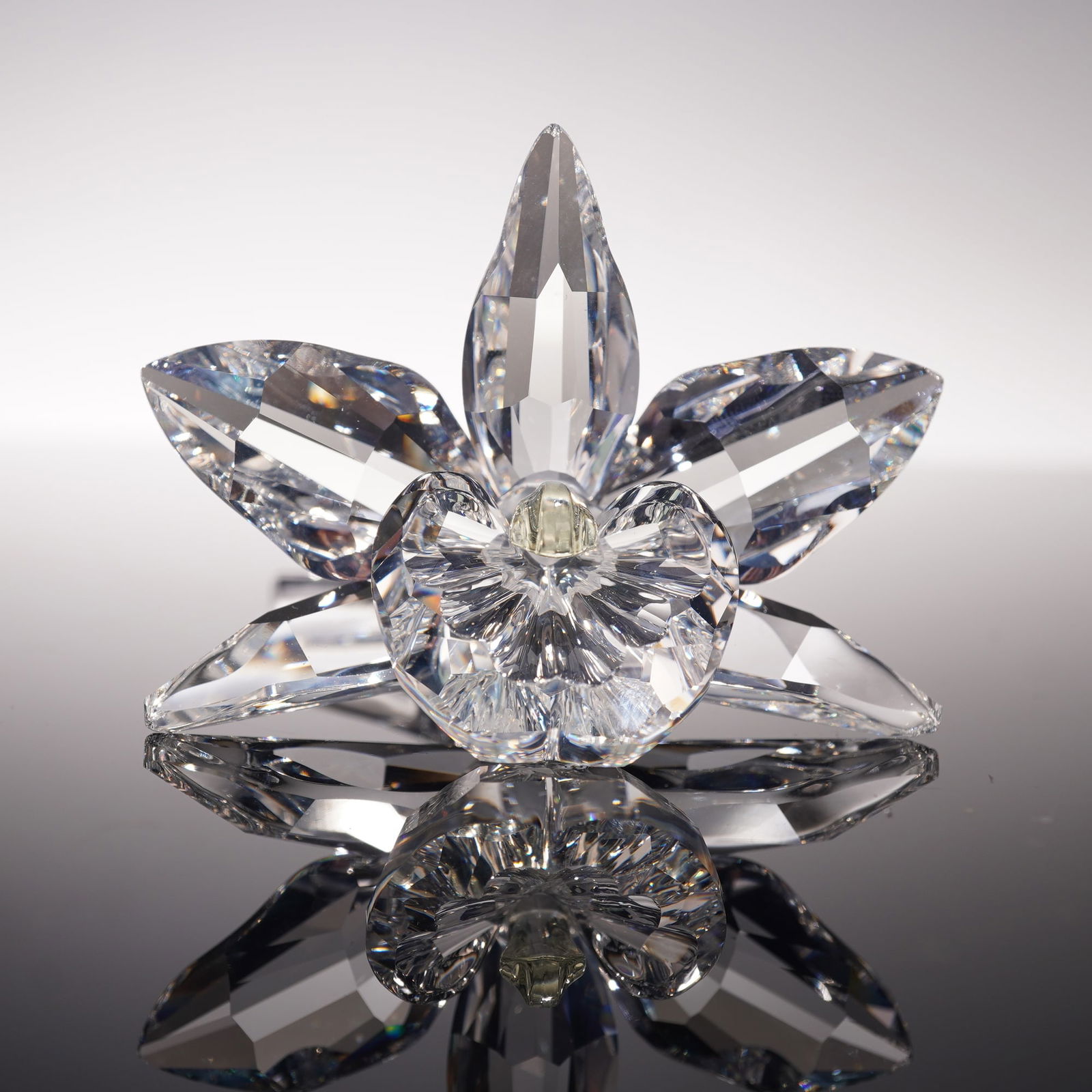 Swarovski Crystal Figurine, Orchid Yellow Centre: Swarovski figurine Orchid 200280 crafted in clear faceted crystal with five petals and yellow central bloom, features Swarovski backstamp, includes original Silver Crystal box 4.75"H. Includes a small