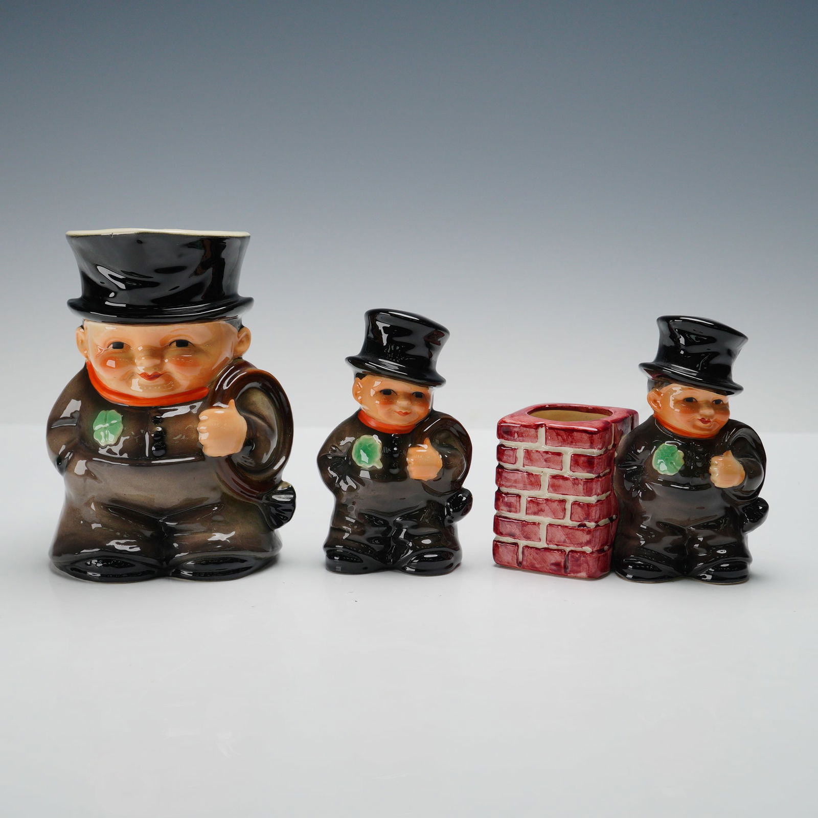 3pc Goebel Hummel Chimney Sweep Group- Jug, Figurine & Toothpick Holder: Charming 3-piece Goebel Hummel grouping featuring the beloved Chimney Sweep motif. Includes a large Toby jug with the chimney sweep in top hat and carrying his tools, a smaller standing figurine, and