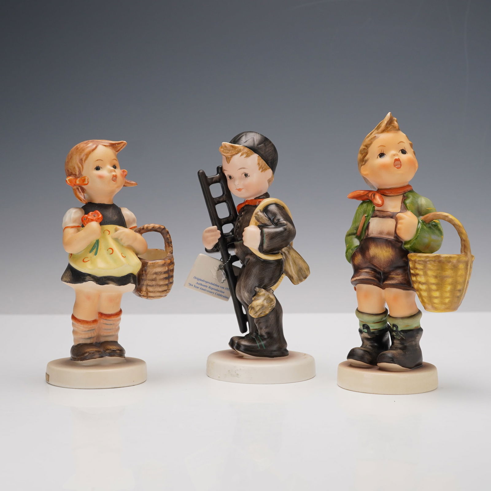 3pc Goebel Hummel Figurines, Sister, Village Boy, and Chimney Sweep: This three piece Goebel Hummel figurine set includes Sister, Village Boy, and Chimney Sweep. Sister holds a basket and a small flower, wearing a black dress with a yellow apron. Village Boy stands wit