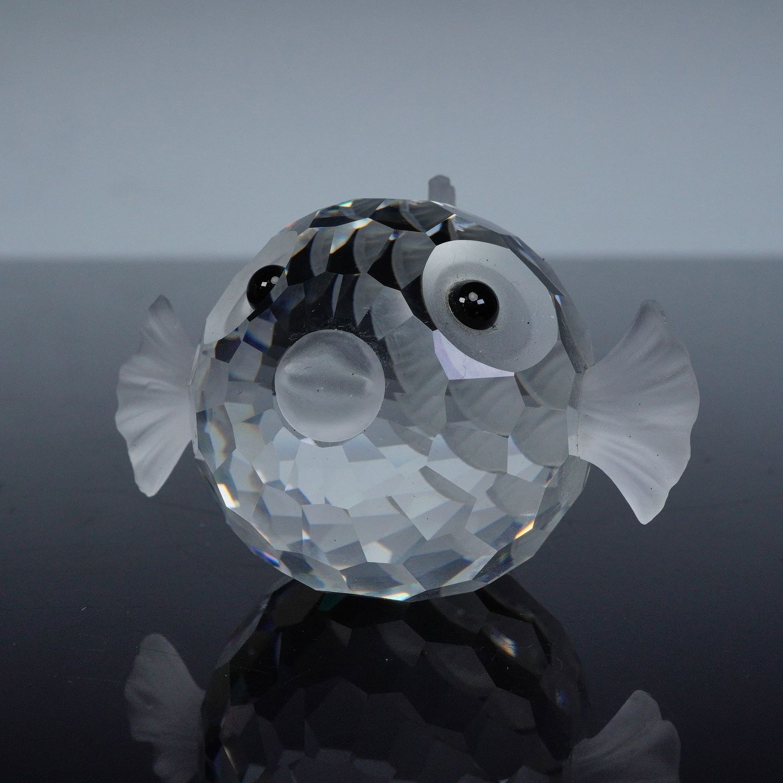 Swarovski South Sea Crystal Figurine, Large Blowfish: This charming crystal sculpture captures a whimsical blowfish with a round, faceted clear crystal body that reflects light brilliantly from every angle. Frosted crystal accents form its fins, tail, an