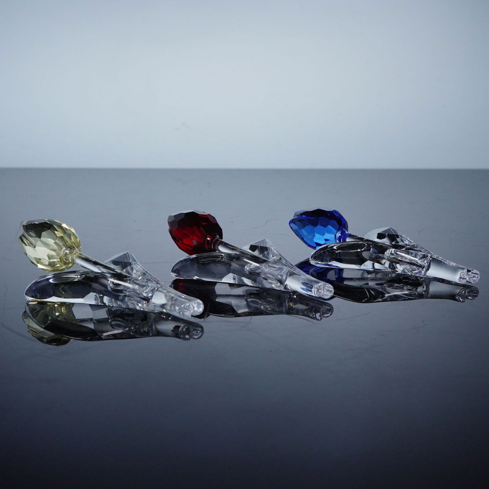 3pc Swarovski Crystal SCS Tulips: A charming trio of Swarovski crystal tulips, each delicately crafted with precision and clarity. This set includes one tulip with a yellow crystal bloom, one with a red bloom, and one with a blue bloo