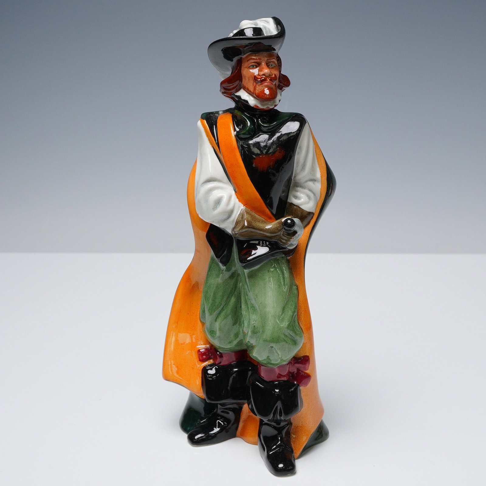 Royal Doulton Porcelain Figurine, Cavalier HN2716: A vivid Royal Doulton porcelain figurine from the Men of History series, depicting the confident Cavalier HN2716. Designed by Eric J. Griffiths and issued between 1976 and 1982, this bold figure featu
