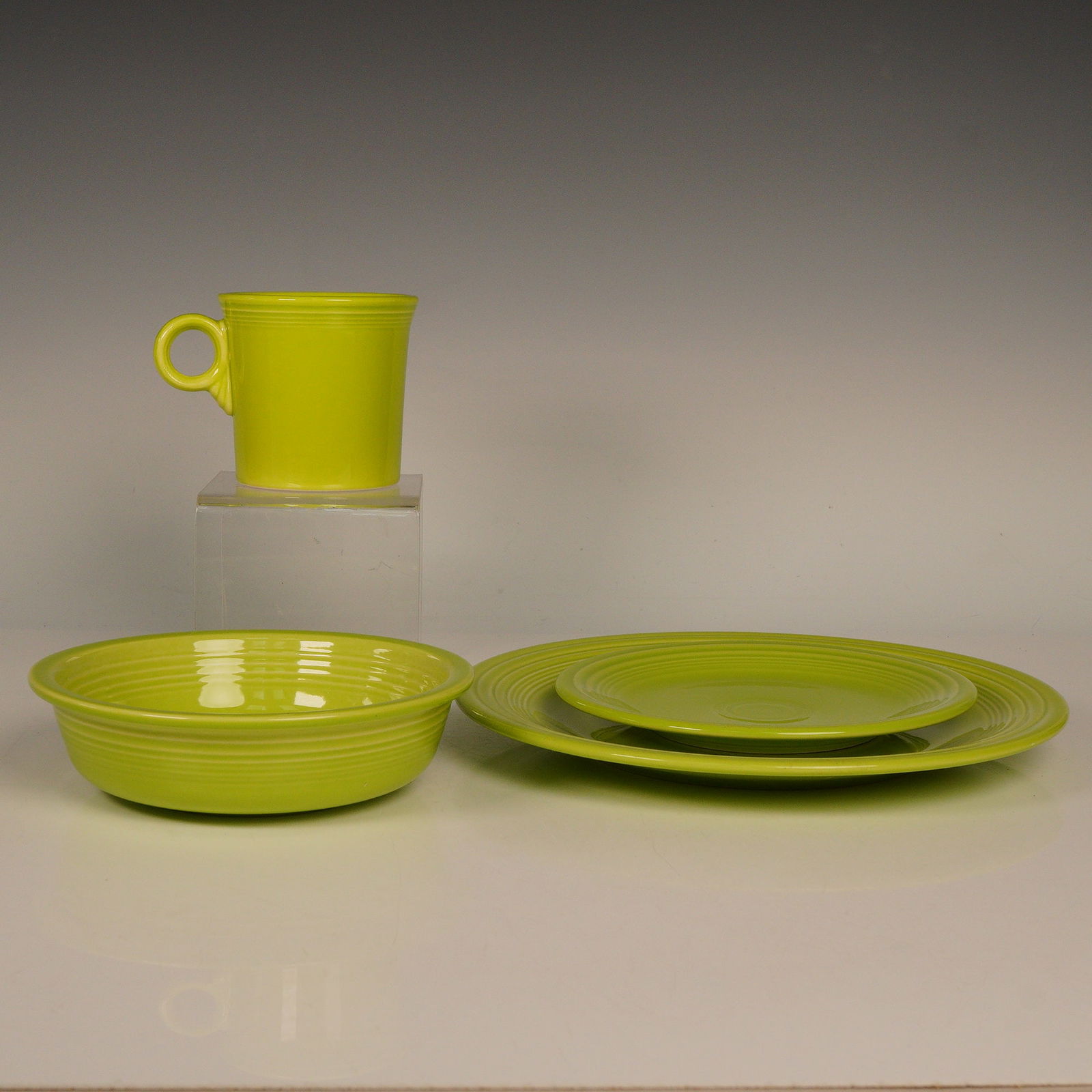 4pc Homer Laughlin China Fiestaware Set, Chartreuse: Part of the iconic Fiestaware line in chartreuse. The collection includes a dinner plate, salad plate, soup or cereal bowl, and mug, each showcasing Fiesta's signature concentric ring design and gloss