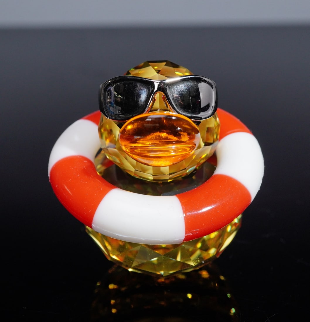 Swarovski Crystal Happy Duck Figurine, Sunny Sam: This playful Swarovski Happy Duck figurine, Sunny Sam, radiates character and charm. Crafted with a fully faceted Light Topaz crystal body and head, the design is accented by a bright Sun crystal beak