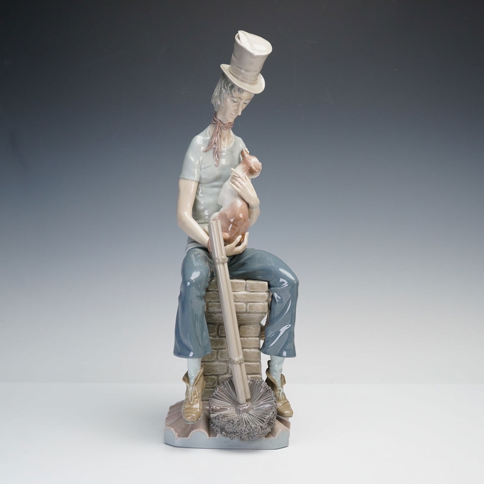 Lladro Figurine, Sad Chimney Sweep 1001253: Lladro porcelain figurine titled Sad Chimney Sweep, sculpted by Salvador Furio. Depicts a seated chimney sweep holding a small cat in his lap, wearing a tall hat and resting beside his tools. Issued i